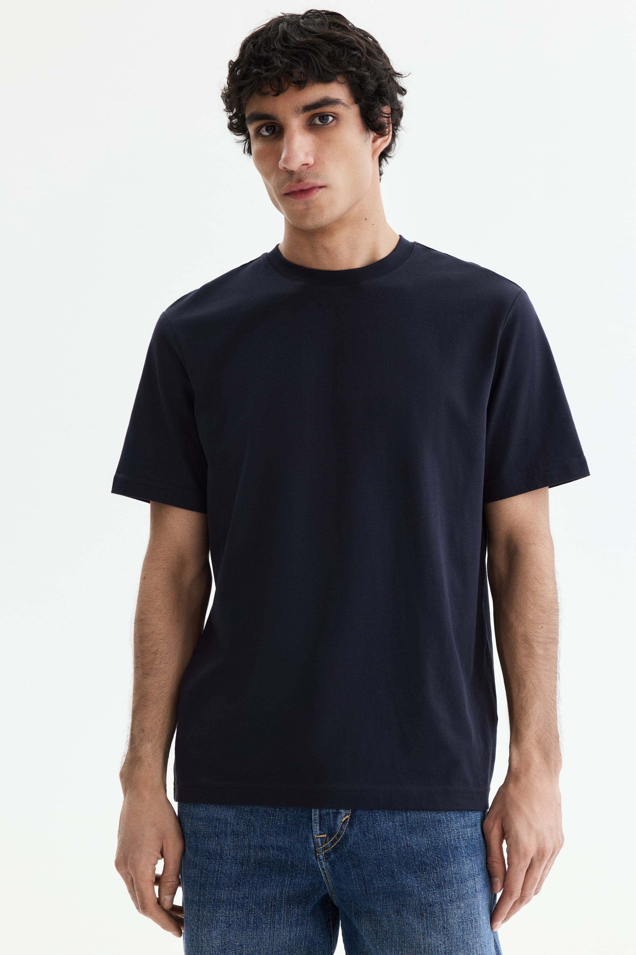 View larger image: A dark blue T-shirt is presented facing forward, featuring a crew neck, short sleeves, and smooth fabric. It displays a relaxed fit with a straight hem.