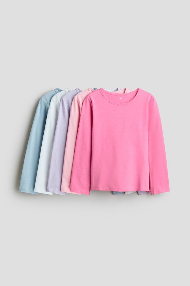 Magliette a maniche lunghe in morbido jersey di cotone con scollo rotondo e bordo sottile. Sono disposte frontalmente in una disposizione a ventaglio, mostrando una varietà di colori pastello. - 1