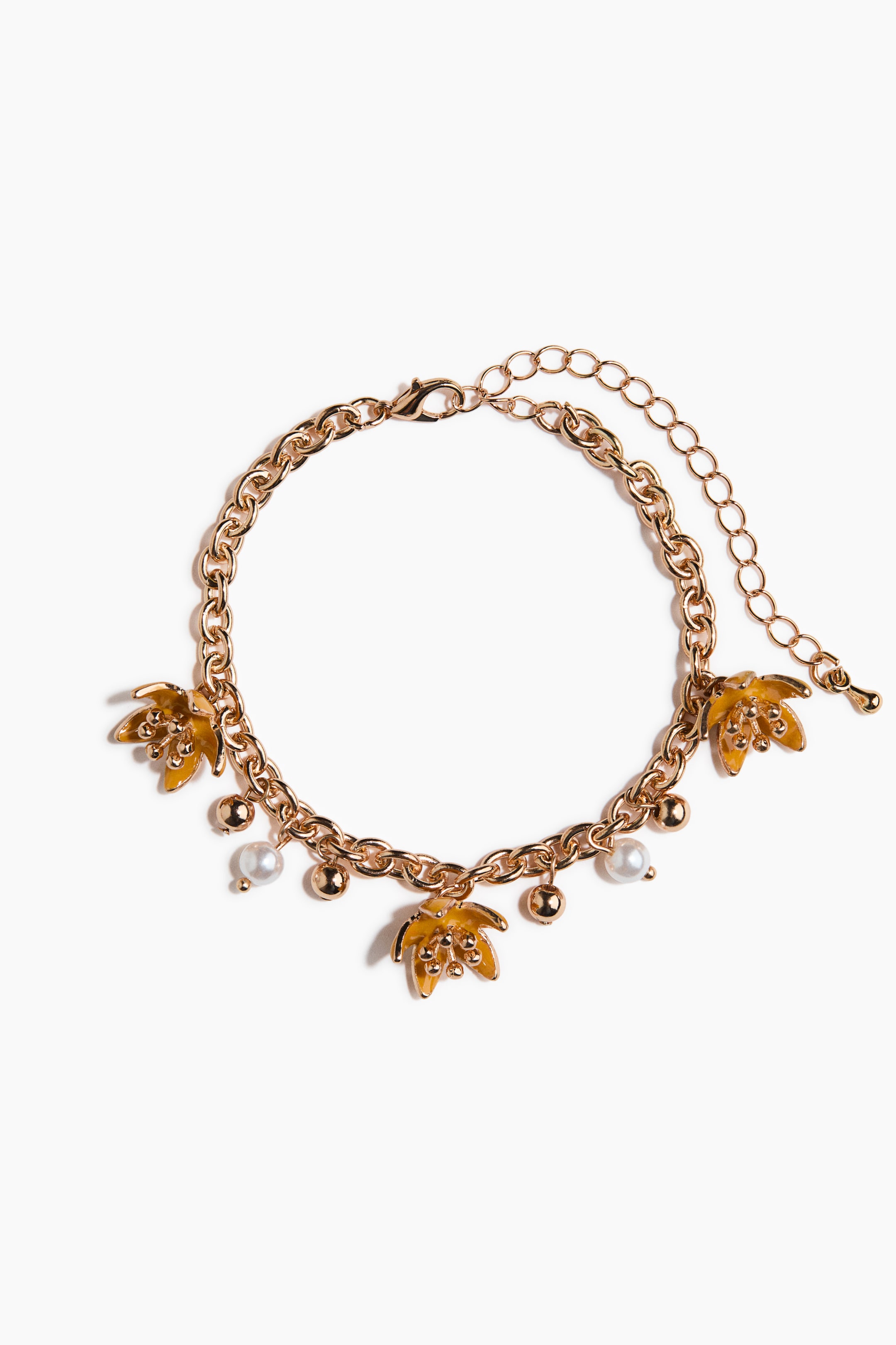 Grotere afbeelding bekijken: Een armband met goudkleurige schakels toont zijn VOORZIJDE, met drie geel-geëmailleerde palmblad bedeltjes met kleine gouden stippen, vijf kleine goudkleurige bolvormige kralen, twee witte bolvormige parels, een karabijnsluiting en een verlengketting.