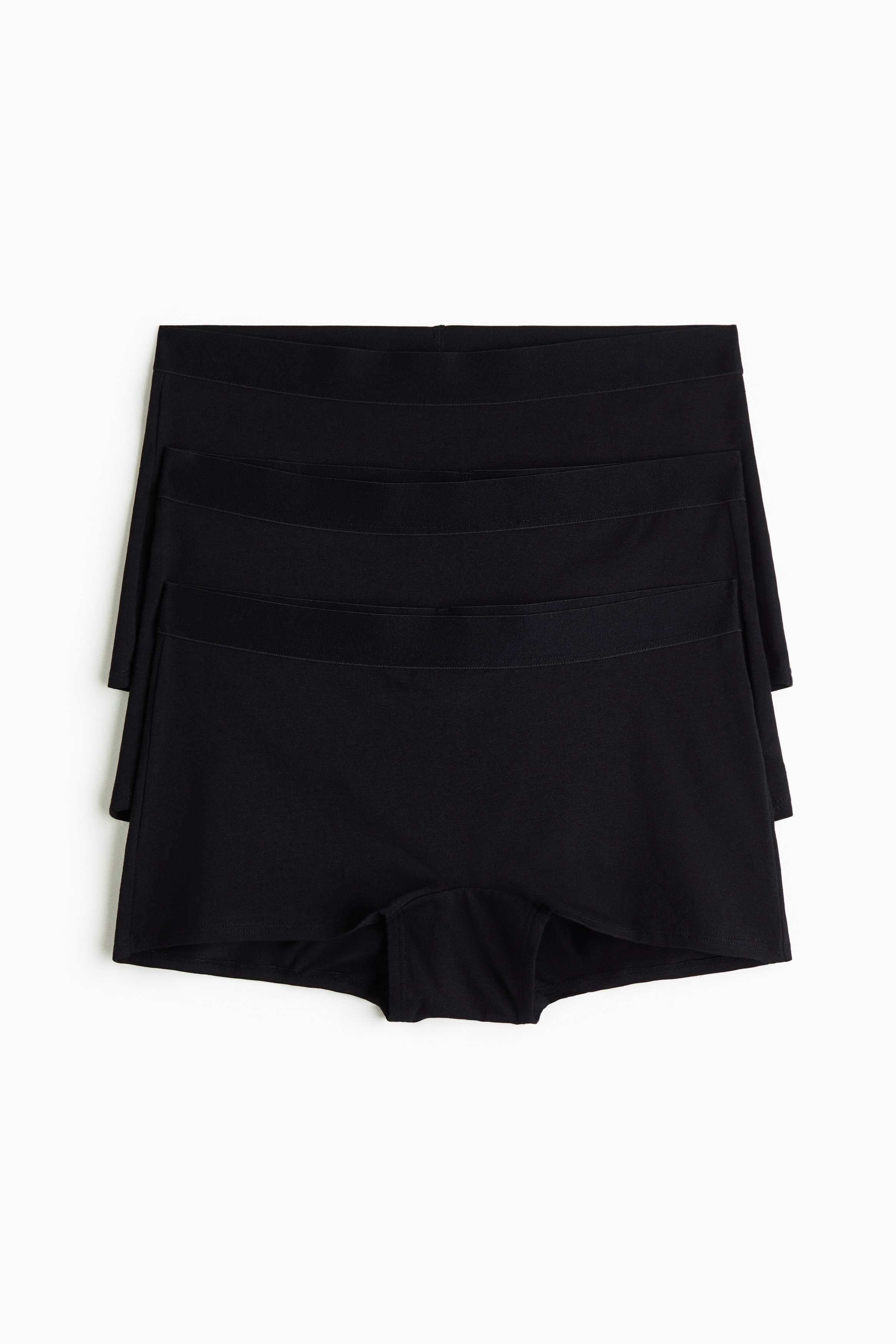 Ein schwarzer BH und passende schwarze Boyshorts werden aus einem Dreiviertel-Rückwinkel präsentiert. Der BH verfügt über dünne, verstellbare Schulterträger und einen Verschluss am Rücken, während die Boyshorts ein glattes, figurbetontes Design zeigen.