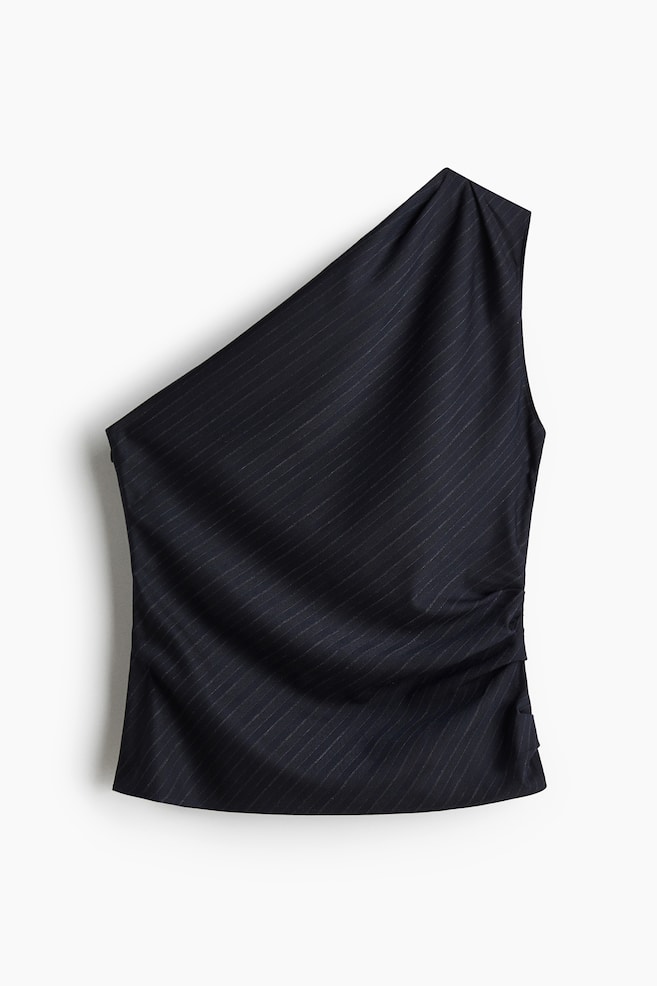 Ein schwarzes One-Shoulder-Top mit diagonalen Nadelstreifen wird von vorne präsentiert und zeigt ein asymmetrisches Design mit einem breiten Panel, das die linke Schulter bedeckt. Vertikale Raffung ist entlang der rechten Seitennaht sichtbar, wodurch Falten im Stoff entstehen. - 1