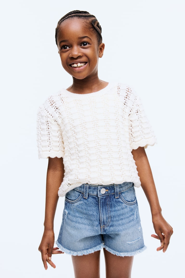 Short frangé en denim