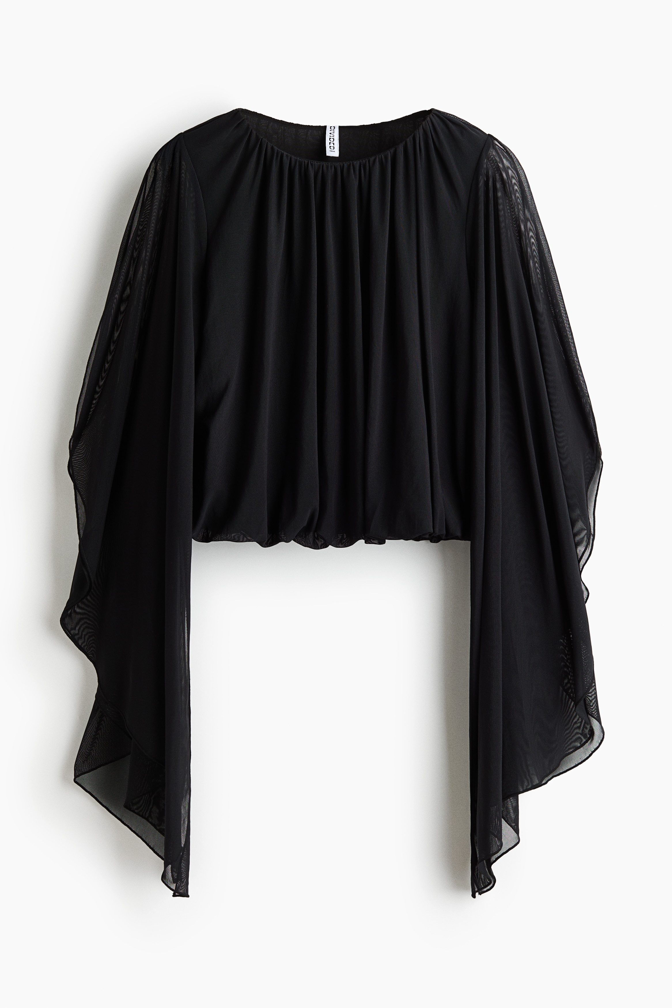 A black, loose-fit cropped top in sheer mesh is worn by the model, featuring a gathered round neckline, a puffed bubble hem, and long, asymmetrical cape sleeves with shoulder slits. The top is partially lined at the bodice and styled with a dark brown ruched skirt.