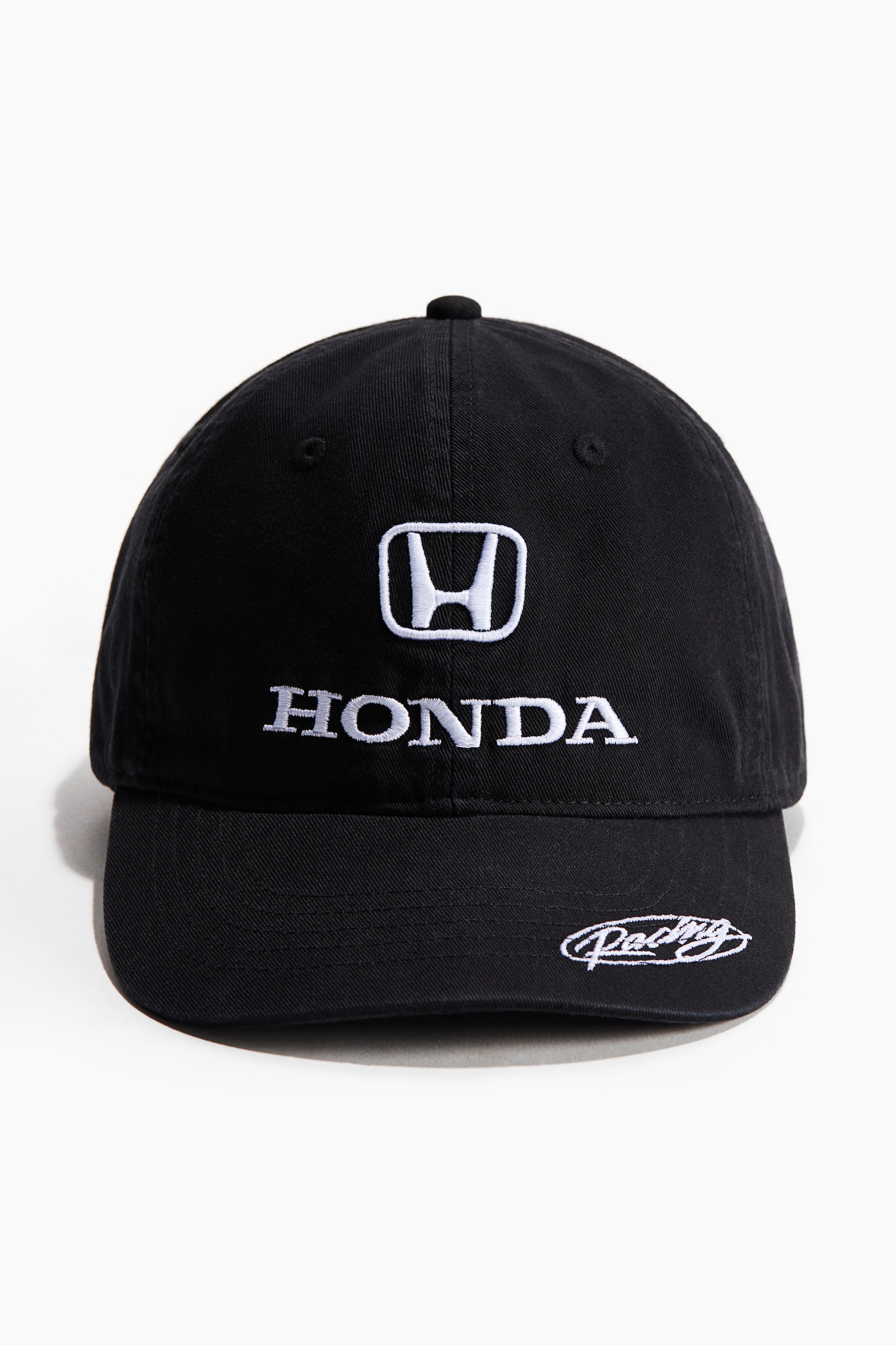 View larger image: A black baseball cap featuring a white embroidered Honda logo and "HONDA" text on the front, with "Racing" embroidered in white script on the brim.