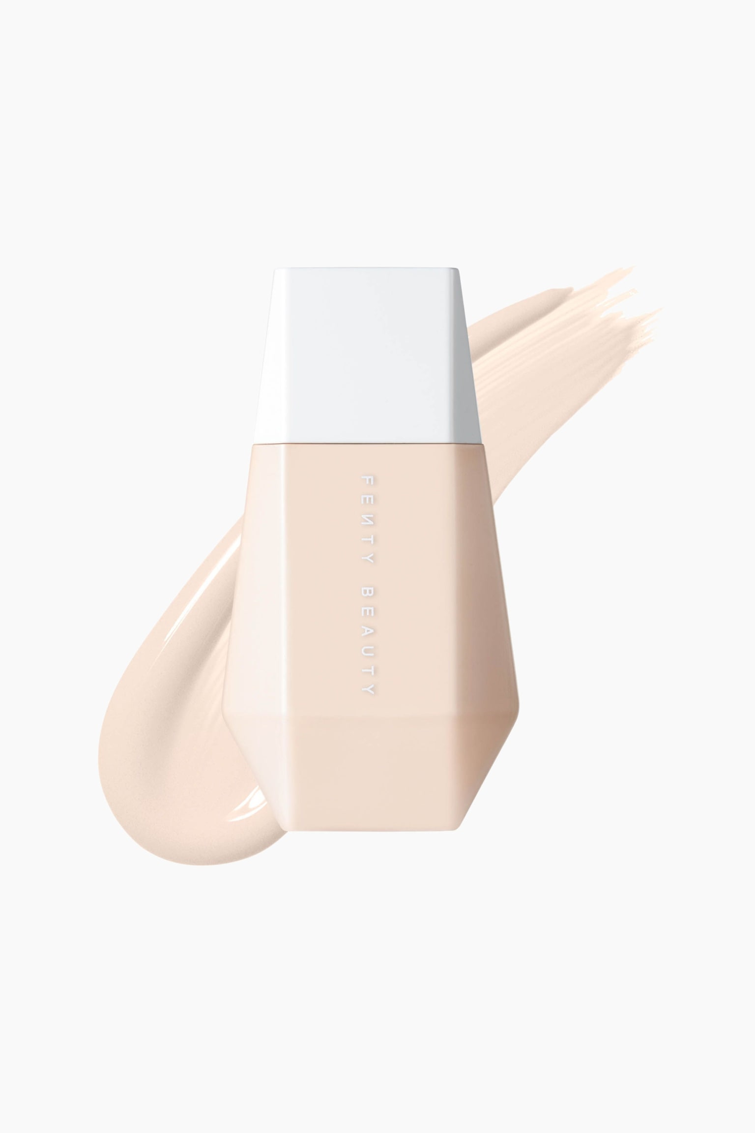 En ljust persikofärgad, kantig flaska med Fenty Beauty skin tint står upprätt och visar sin vita trapetsformade kork och vertikala varumärkestext. Ett slätt, diagonalt prov av ljusbeige flytande foundation sträcker sig bakom flaskan och visar dess krämiga konsistens.