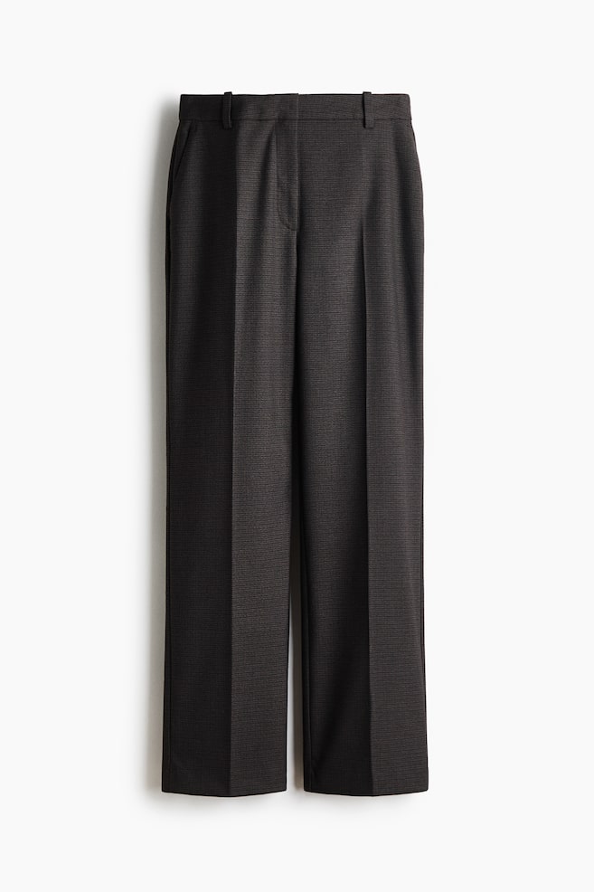 These dark grey, textured trousers are shown from the front, featuring a straight-leg silhouette with sharp pressed creases running down the centre of each leg. They are displayed with a waistband with belt loops, a concealed front fastening, and subtle side pockets. - 1