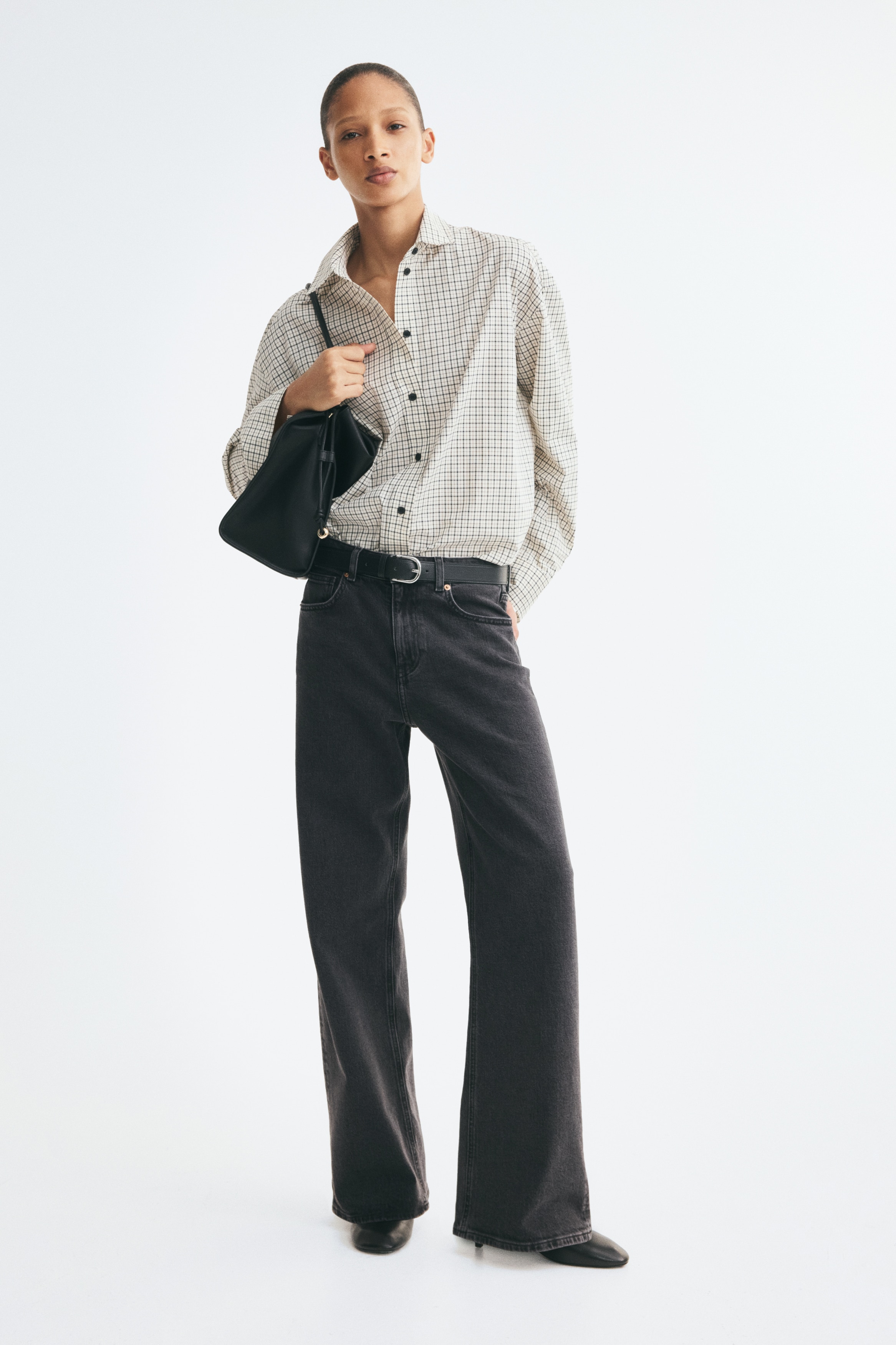 Một chiếc quần jeans 5 túi đang được trình bày ở góc nhìn TRƯỚC, được làm từ chất liệu vải denim cotton xám đậm đã giặt. Nó có đặc điểm cạp cao, khóa kéo với nút cài, và ống rộng, thẳng.