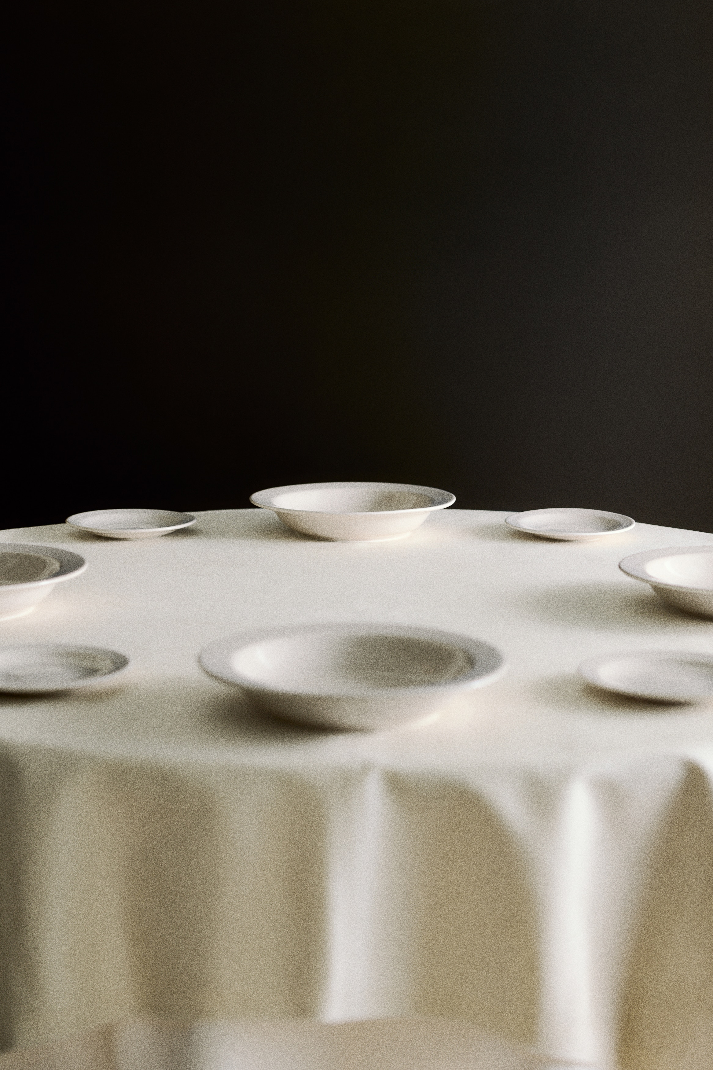 Two light beige bowls are depicted from an overhead perspective, each showcasing a broad rim and a gently curved shallow interior. They are positioned vertically, one placed above the other.
