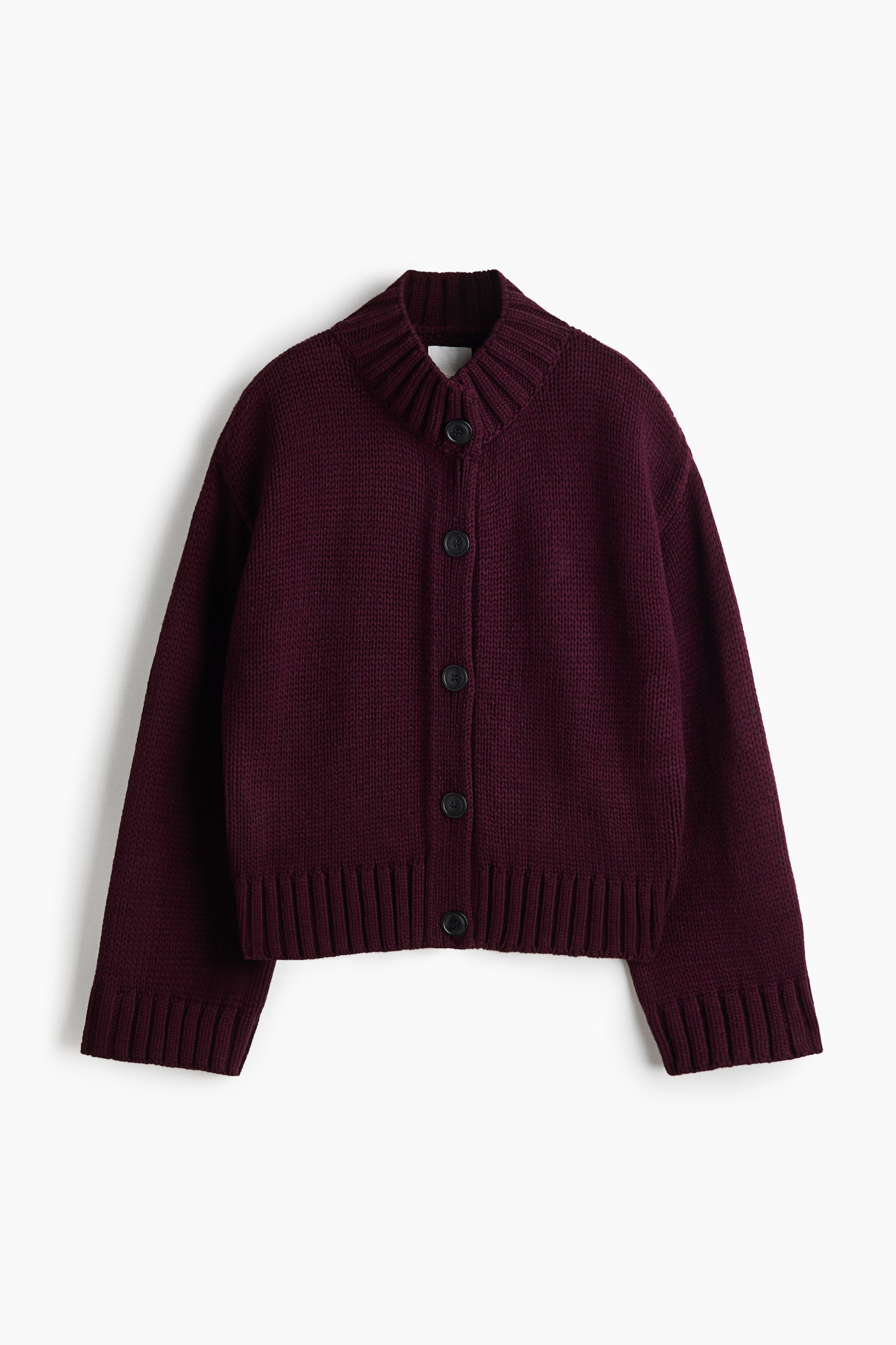 View larger image: A deep burgundy knit cardigan is shown from the front, featuring a high ribbed collar, a button-front closure with five dark buttons, and long sleeves with wide ribbed cuffs. The cardigan features a chunky knit texture with a matching ribbed hem.