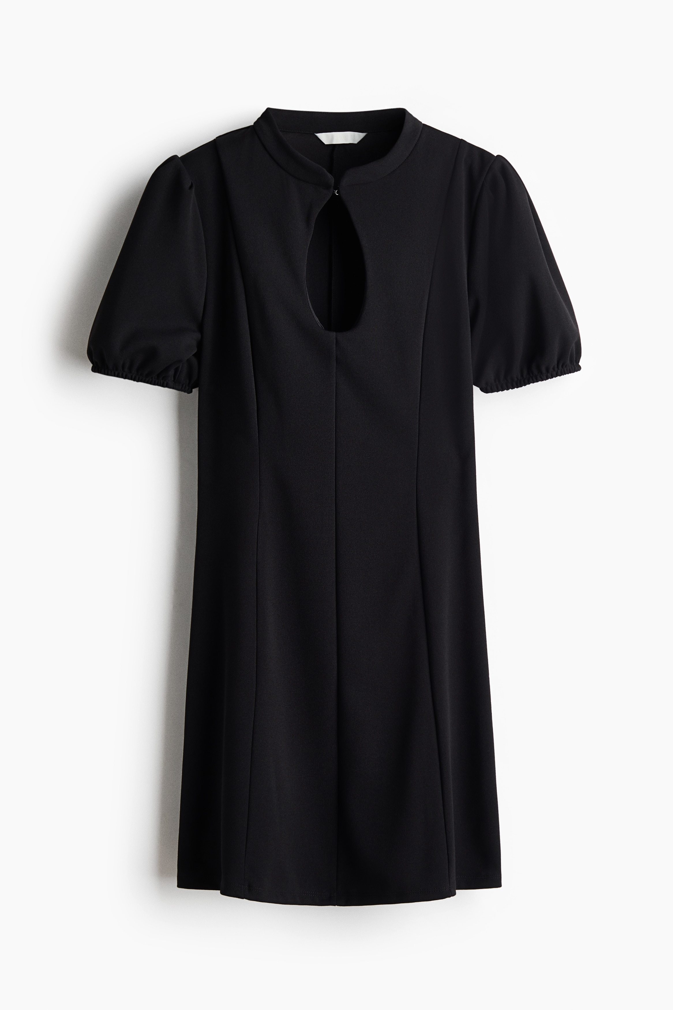 A black mini dress is being worn by the model, featuring a fitted bodice, a high neckline with a front keyhole opening, short puff sleeves, and prominent vertical seams down the front. The dress is styled with black knee-high boots.