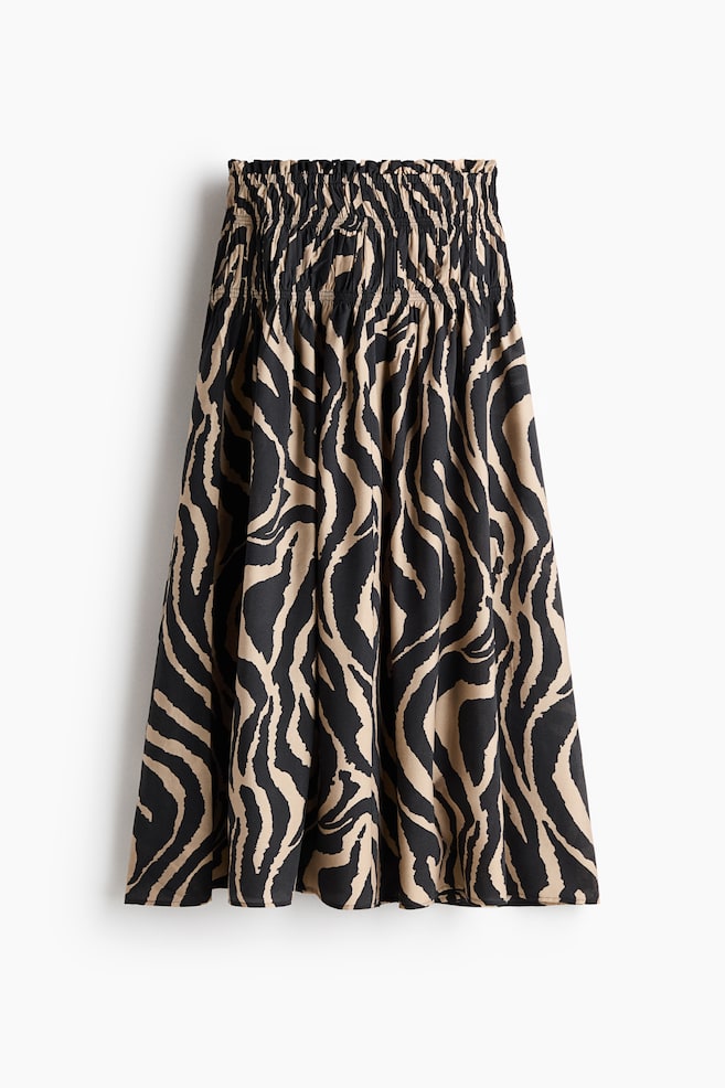 Una falda que exhibe un estampado de cebra en negro y beige, con una pretina fruncida y que cae en una relajada silueta en línea A. - 1