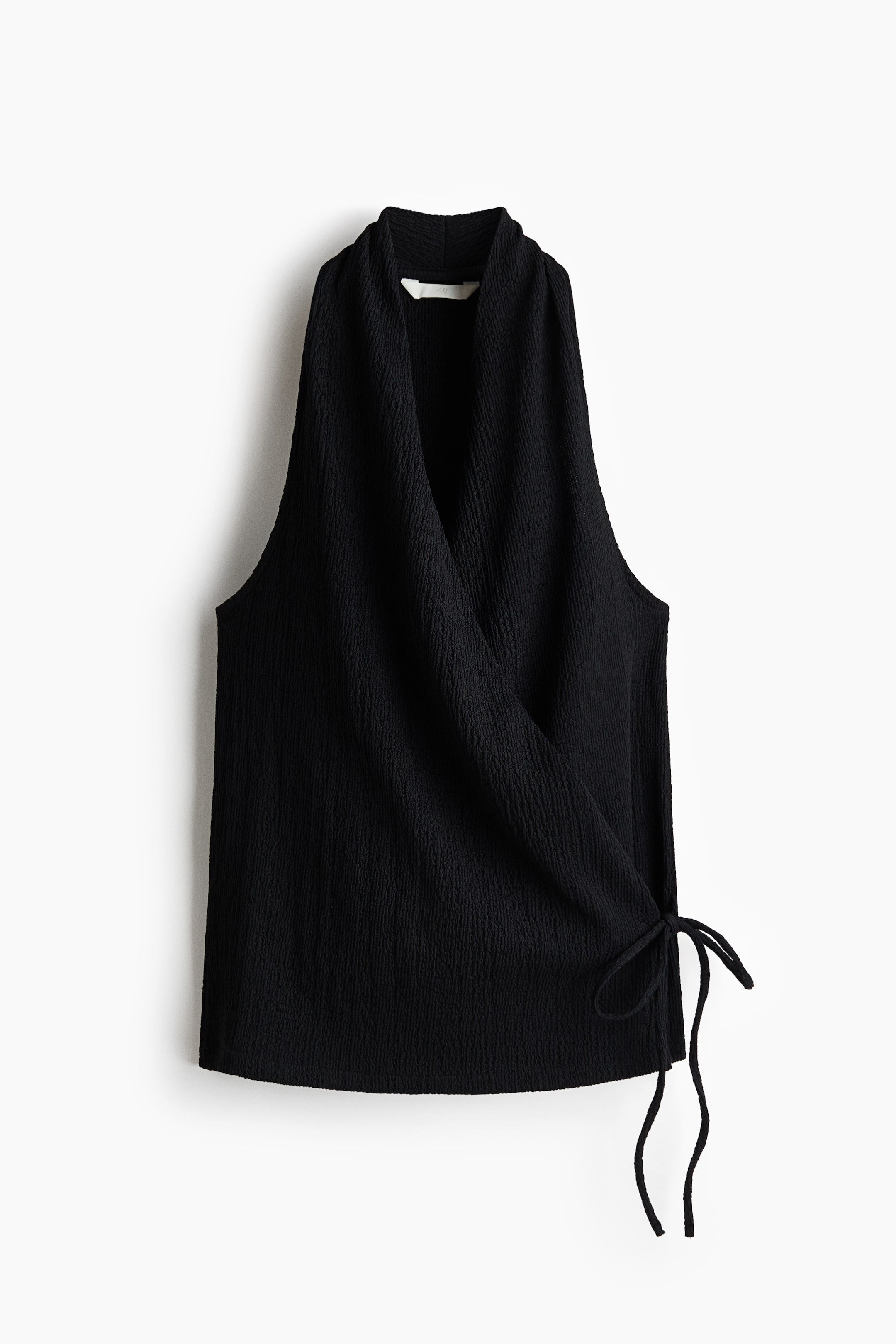 Agrandir l'image: Un top noir sans manches est présenté de face. Il arbore une texture froissée, un devant croisé avec un col en V drapé, et des liens qui sécurisent le côté gauche.