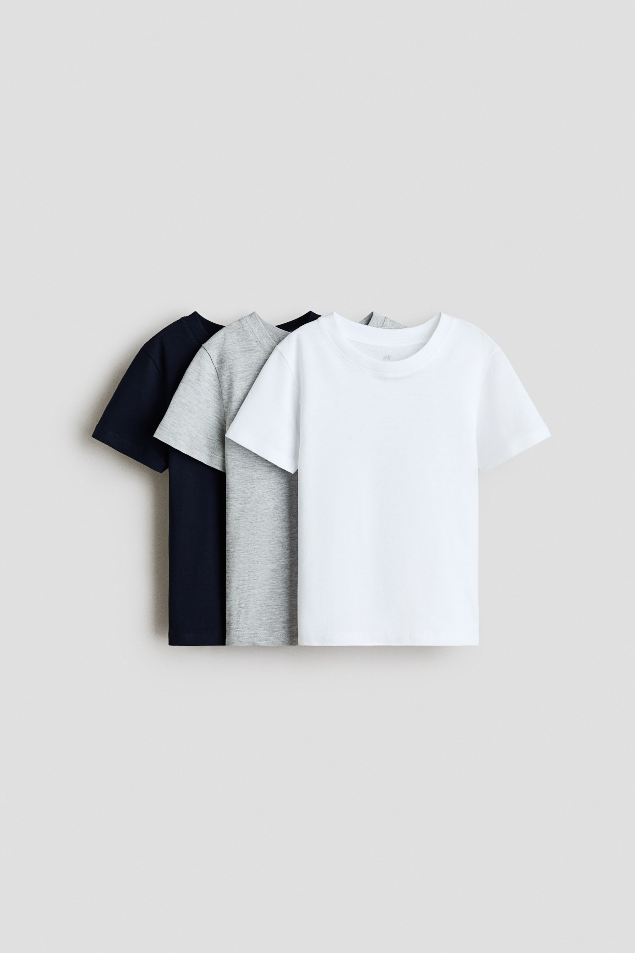 View larger image: Three t-shirts are displayed in front, with a white t-shirt layered over a light gray marl t-shirt, which is layered over a navy blue t-shirt. Each t-shirt features a round, rib-trimmed neckline and is crafted from soft cotton jersey.