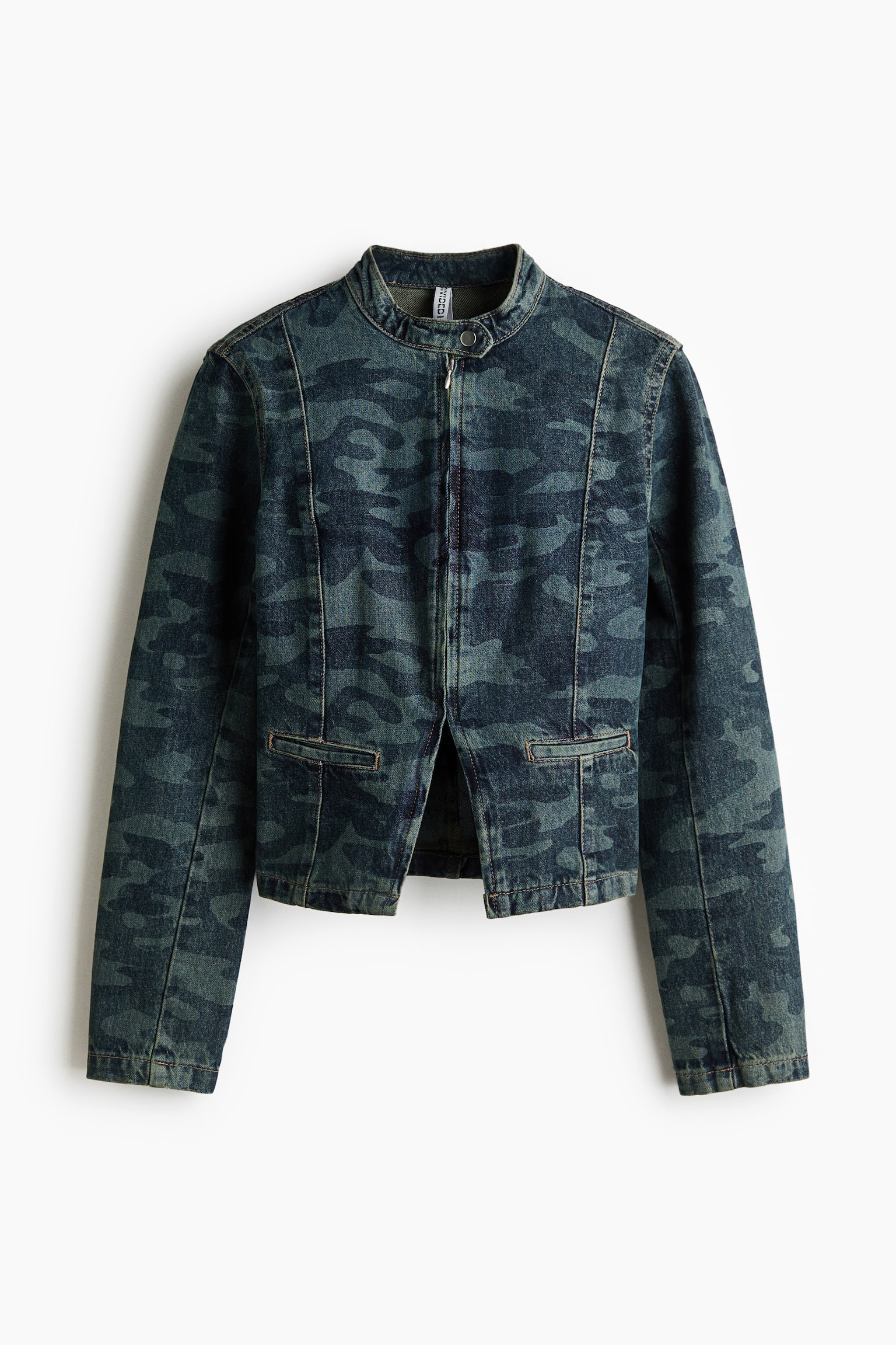 A short, fitted denim jacket in a dark camouflage print is shown from the front, highlighting its structured design. The jacket features a small stand collar with a press-stud throat latch, a zip-front fastening, visible vertical seams, and two front welt pockets.