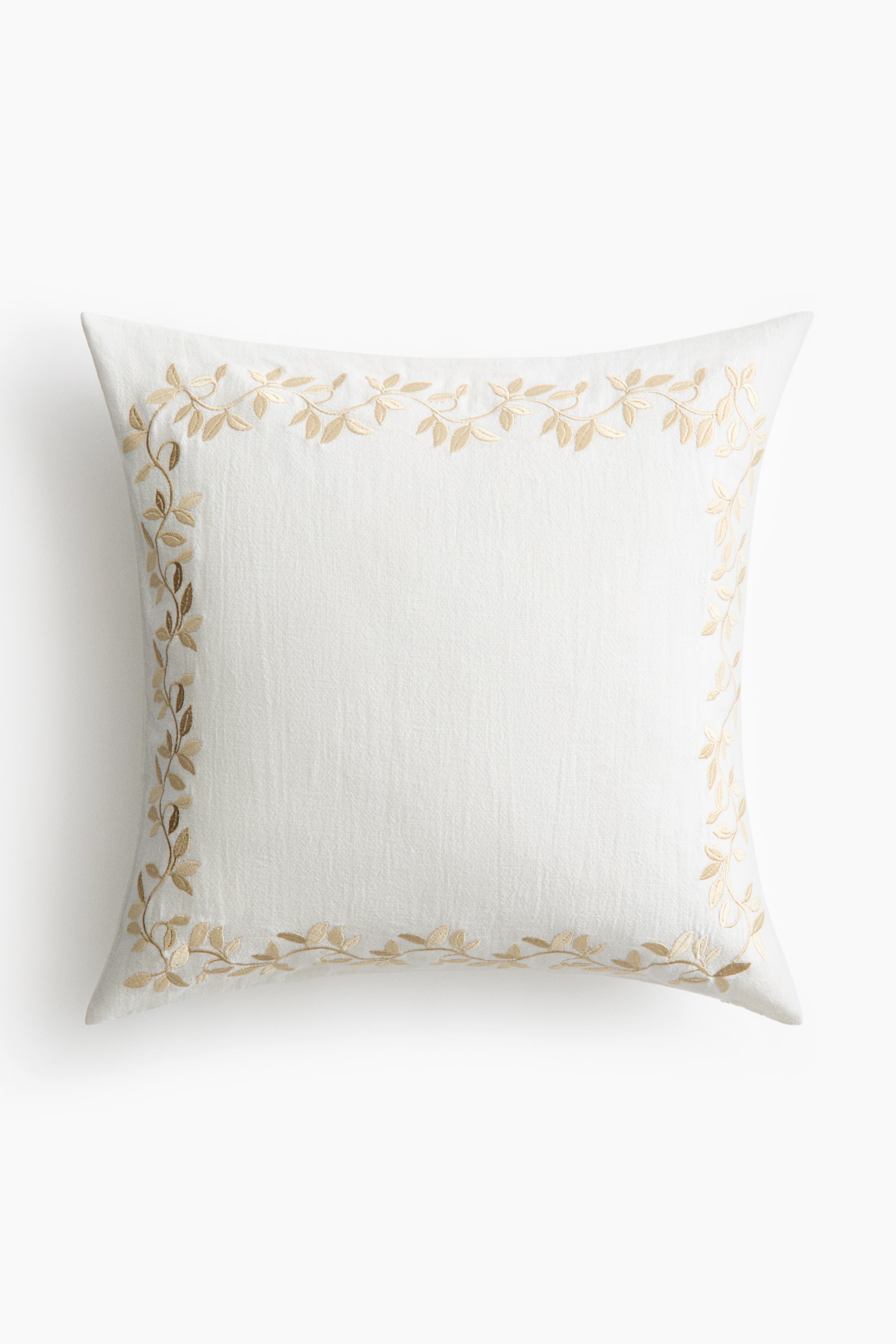 View larger image: A square white scatter cushion is shown from the front, featuring a textured woven cover with a delicate, light beige embroidered vine and leaf border framing the centre.