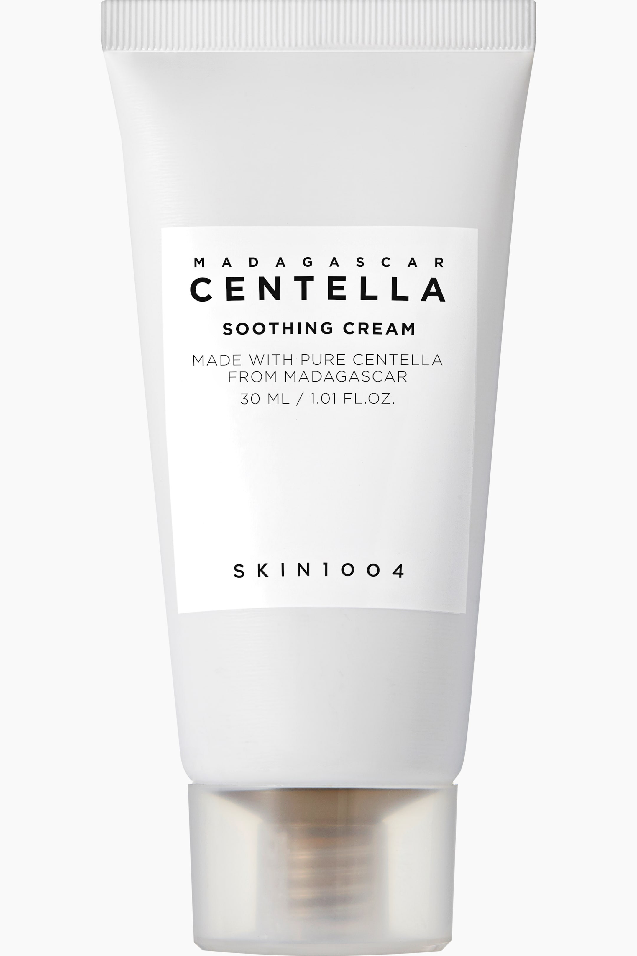 Visa större bild: En vit krämtub står upprätt och visar sin framsida. Den har en matt yta och ett genomskinligt lock vid basen som avslöjar en pumpmekanism. Etiketten visar "MADAGASCAR CENTELLA SOOTHING CREAM," "MADE WITH PURE CENTELLA FROM MADAGASCAR," "30 ML / 1.01 FL.OZ.," och "SKIN1004" med svart text.