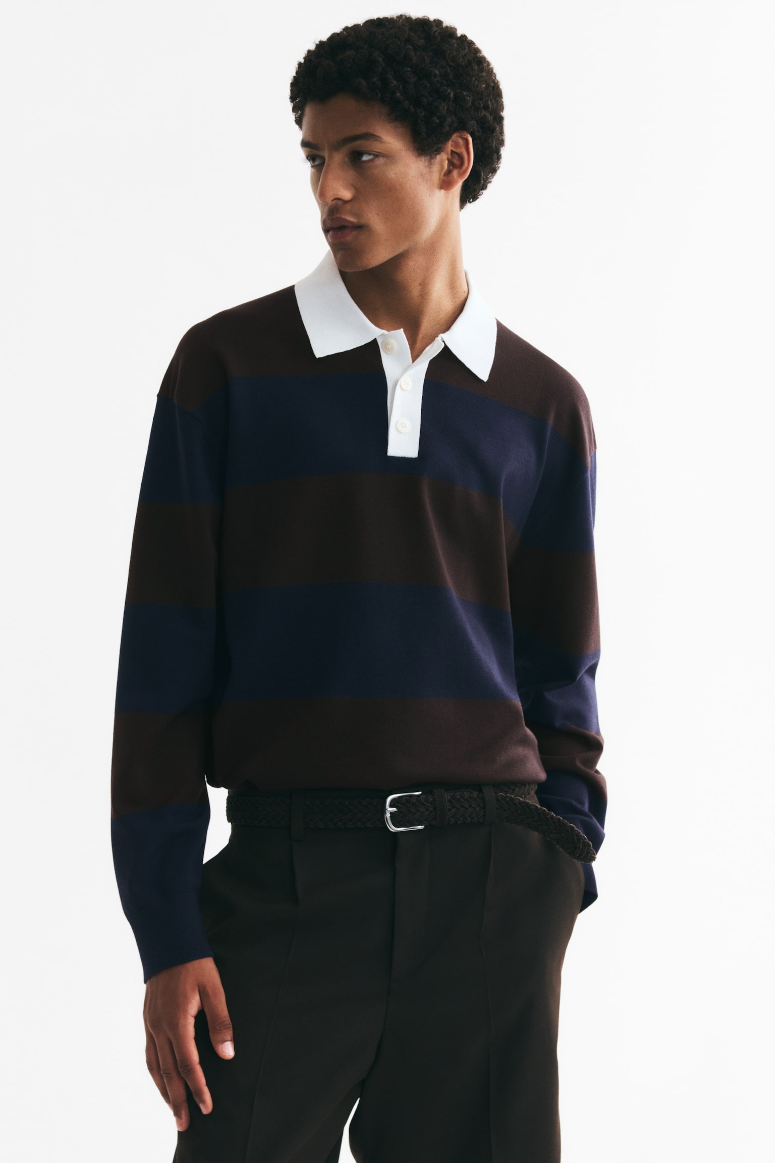 Una camisa polo de manga larga con franjas horizontales alternadas en marrón oscuro y azul oscuro, un cuello blanco contrastante, una tapeta blanca de tres botones, puños acanalados y un dobladillo acanalado. - 1