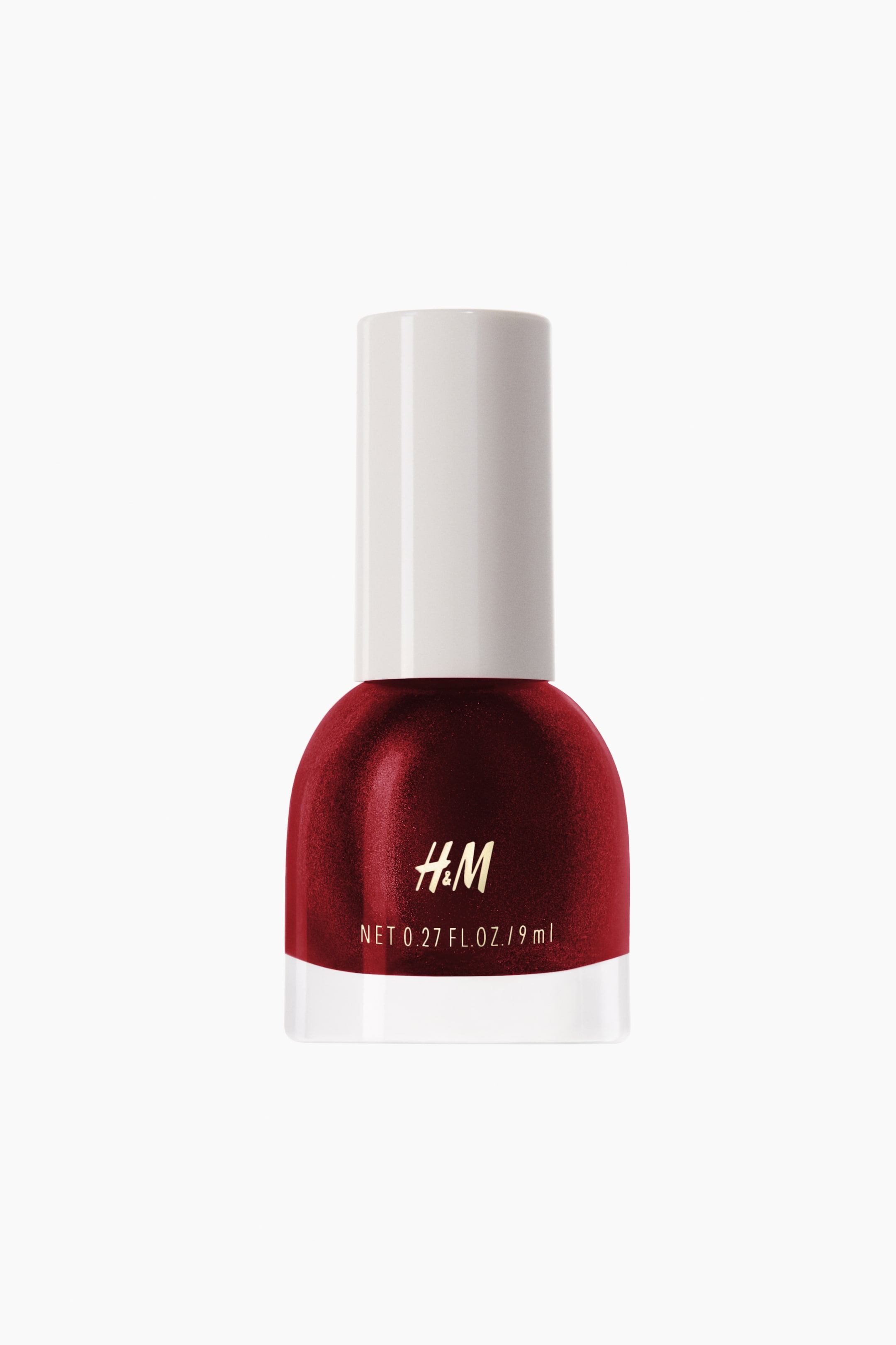 View larger image: Nail polish. The front-facing bottle contains a deep red, shimmery polish, featuring a clear glass base and a white cylindrical cap. The H&M logo and volume details appear in gold text on the front.