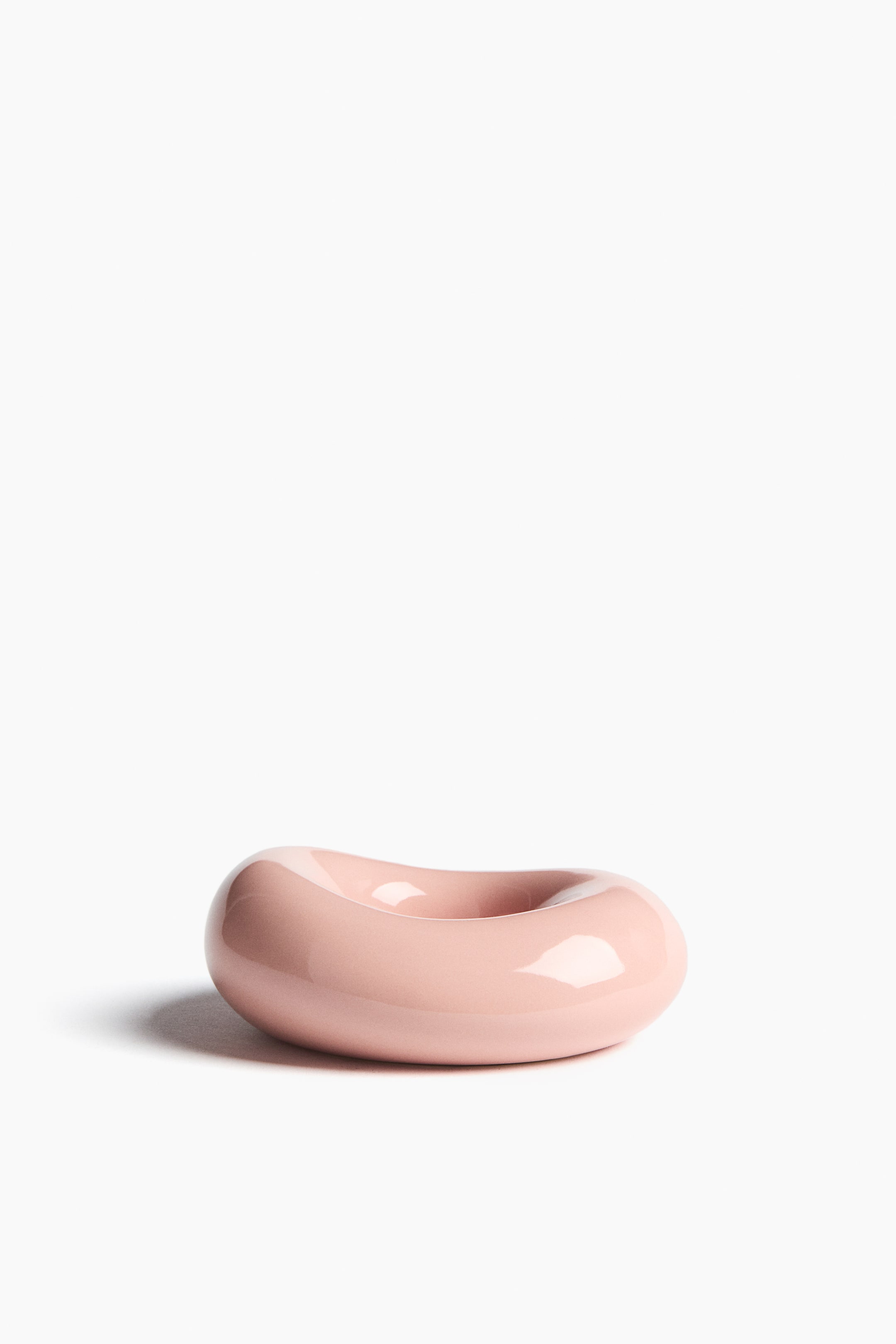 View larger image: A light pink, glossy, toroidal object is resting horizontally. It is featuring a smooth, rounded form with a subtle indentation on its top surface.