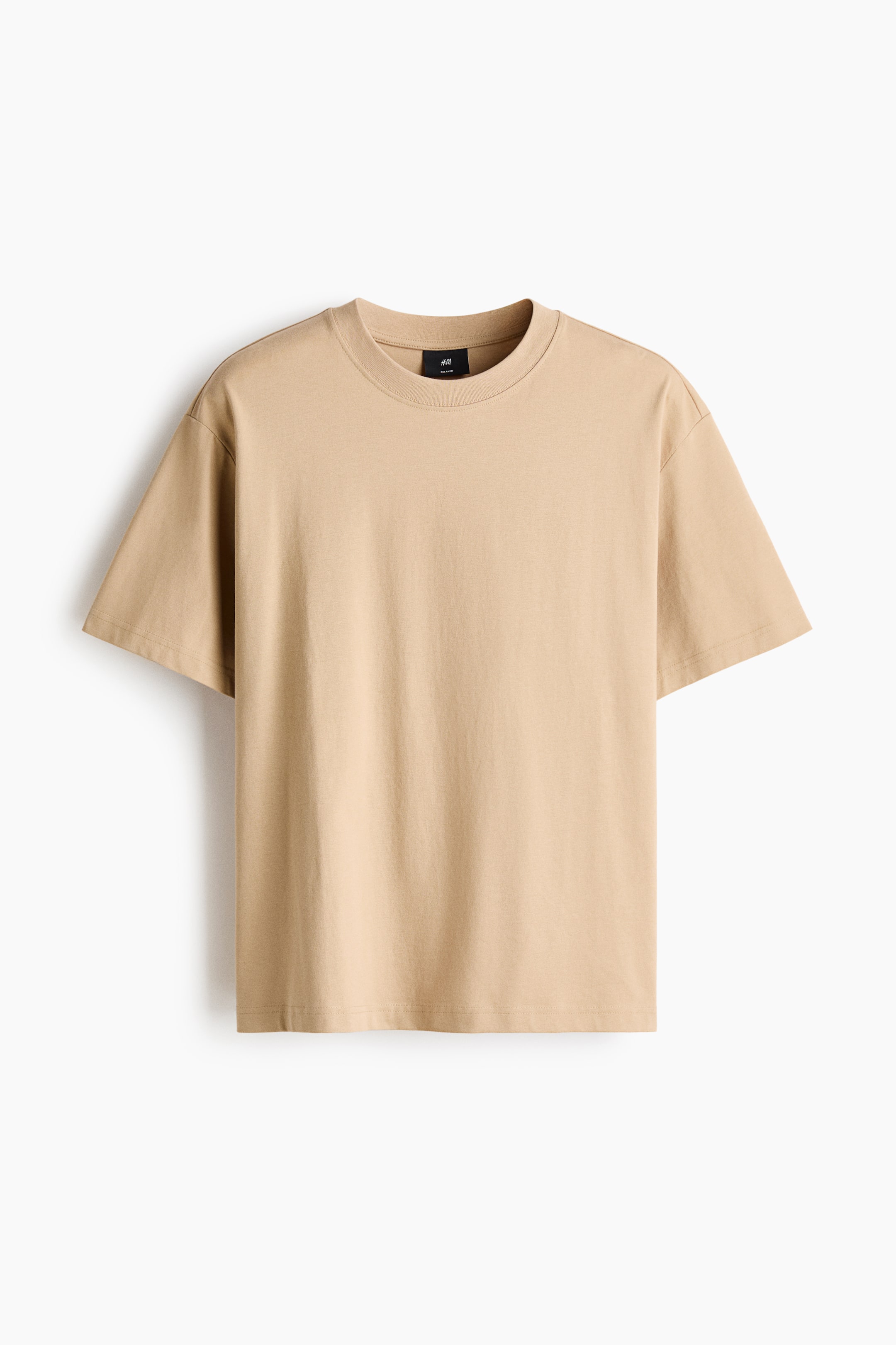 Agrandir l'image: Un t-shirt en jersey beige, présenté de face, doté d’un col rond en bord-côte, d’épaules tombantes, d’un ourlet droit et d’une coupe ample.