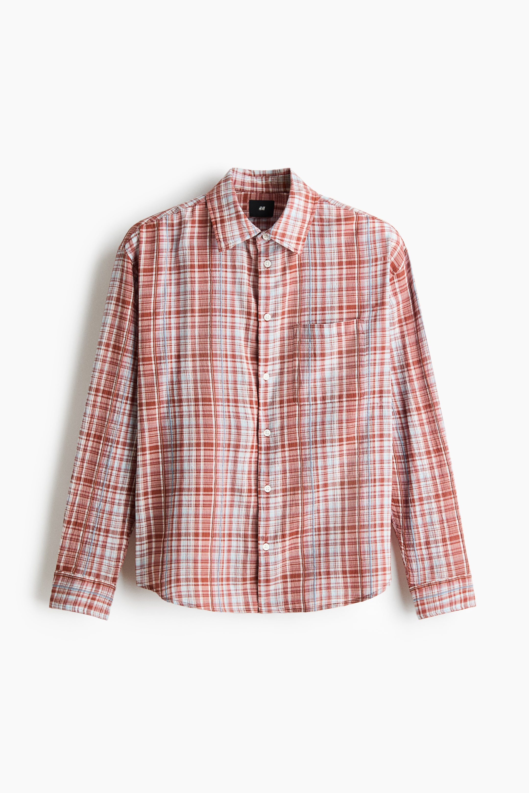 View larger image: A long-sleeved plaid shirt is showcasing its front view, featuring a red-brown, white, and light blue pattern. It is presenting a spread collar, a full button-front closure with white buttons, and a single patch pocket on the left chest with buttoned cuffs on the long sleeves.