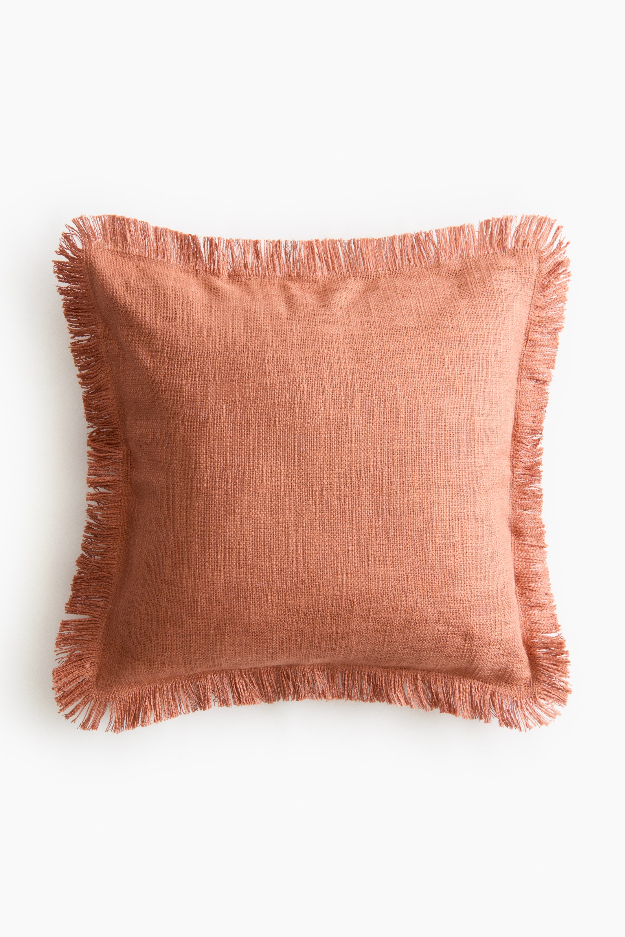 View larger image: The cushion cover is facing front, showcasing a burnt orange slub weave texture with fringes bordering all sides.