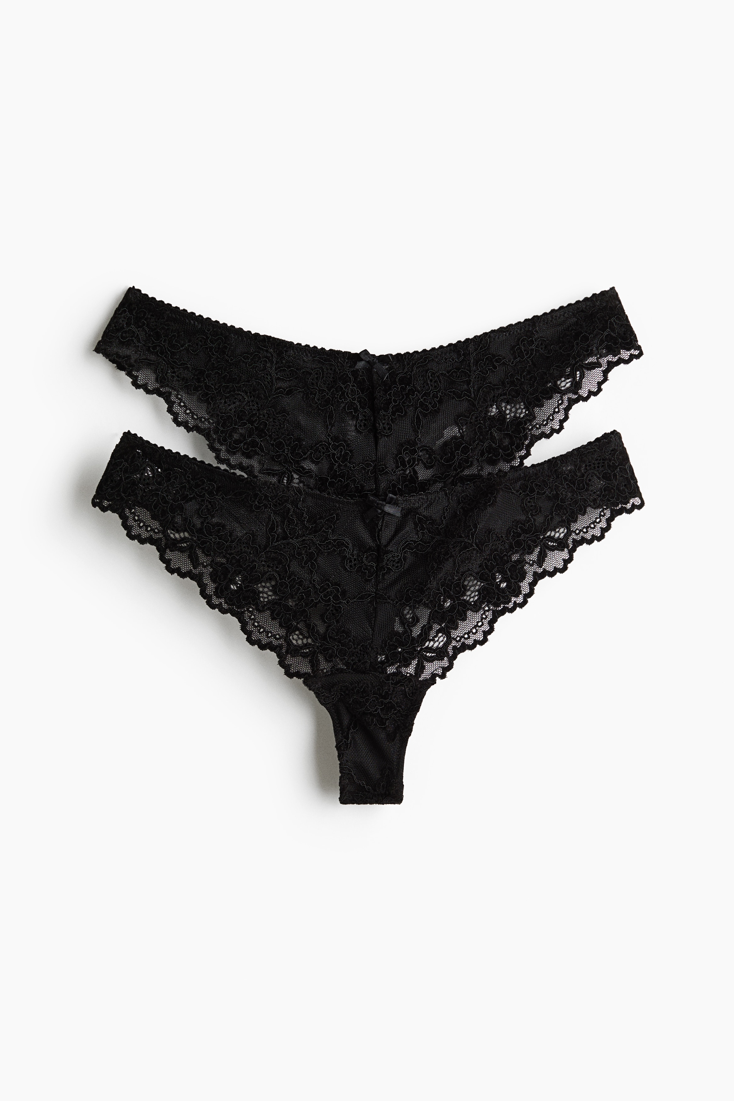 Model, dÃ¼ÅÃ¼k bel kesime sahip siyah iÅlemeli file G-string giyiyor ve bunu uyumlu siyah dantelli bralet ile kombinliyor. Her iki parÃ§a da zarif Ã§iÃ§ek desenli dantel detaylarÄ± ve taraklÄ± kenarlarÄ±yla Ã¶ne Ã§Ä±kÄ±yor.