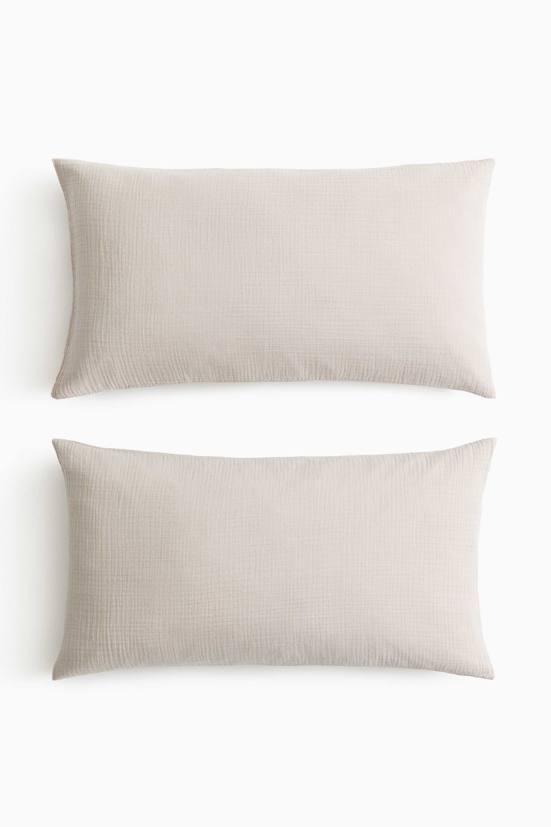 View larger image: Two light beige rectangular cushions feature a crinkled gauze texture. They are positioned horizontally, one above the other.