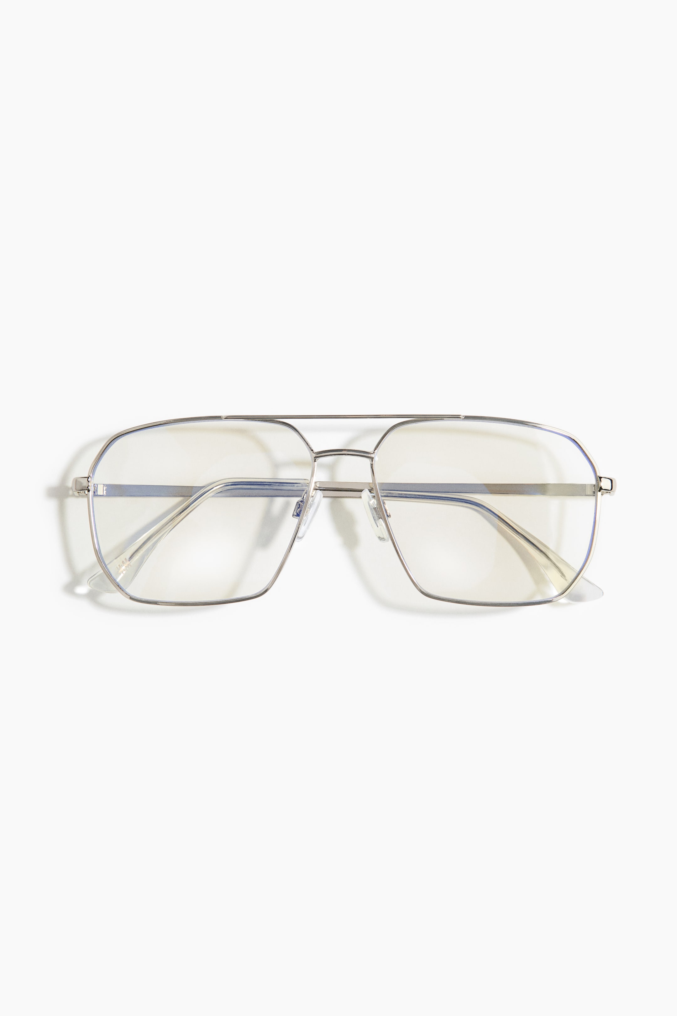 View larger image: Front view of glasses presenting thin, silver-toned metal frames with a double bridge design. The transparent, rectangular plastic lenses feature a blue light filtering coating, exhibiting a subtle yellow tint and blue reflections.