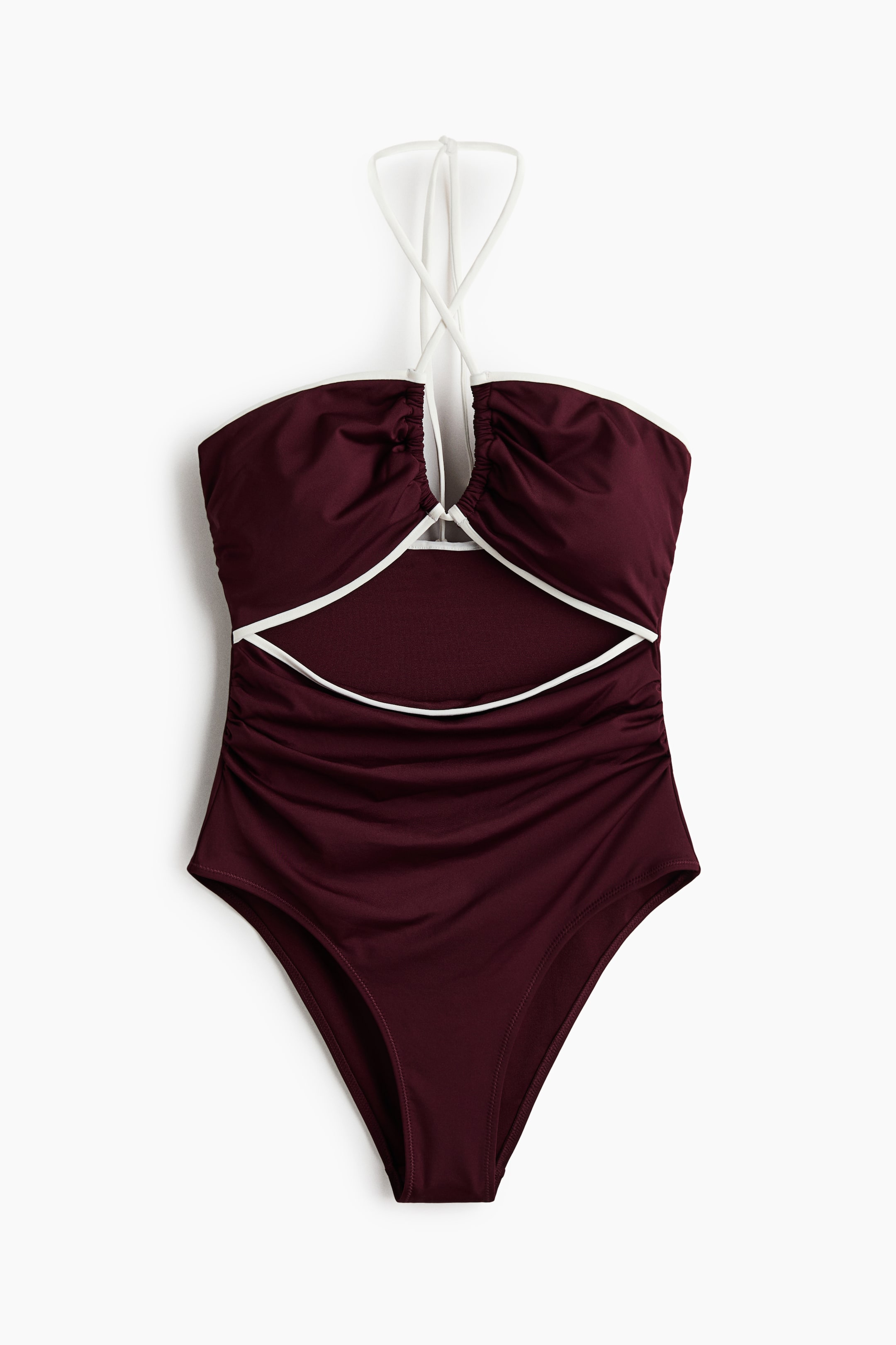 View larger image: A burgundy swimsuit is showcased from the front, highlighting a front cut-out section outlined with white piping that also trims the top edge. Slim white halterneck ties run through the center of the bust, acting as a drawstring, with ruching visible along the sides of the torso.