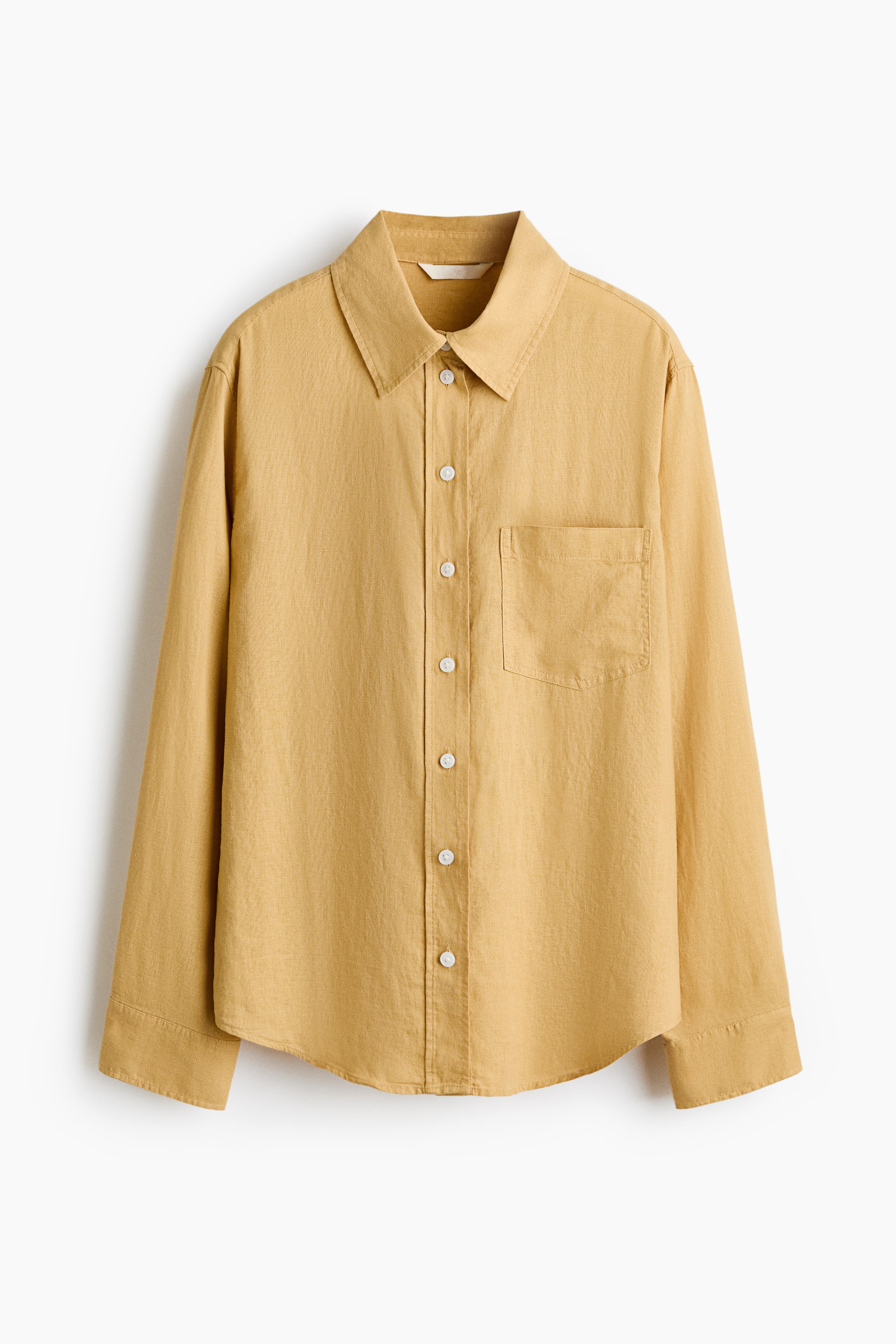 View larger image: A loose-fit shirt crafted from a breathable linen and viscose blend is displayed from the front. It showcases a collar, a button-down front, and an open chest pocket. The design includes long sleeves with buttoned cuffs, a curved hem, and a yoke with a box pleat at the back.