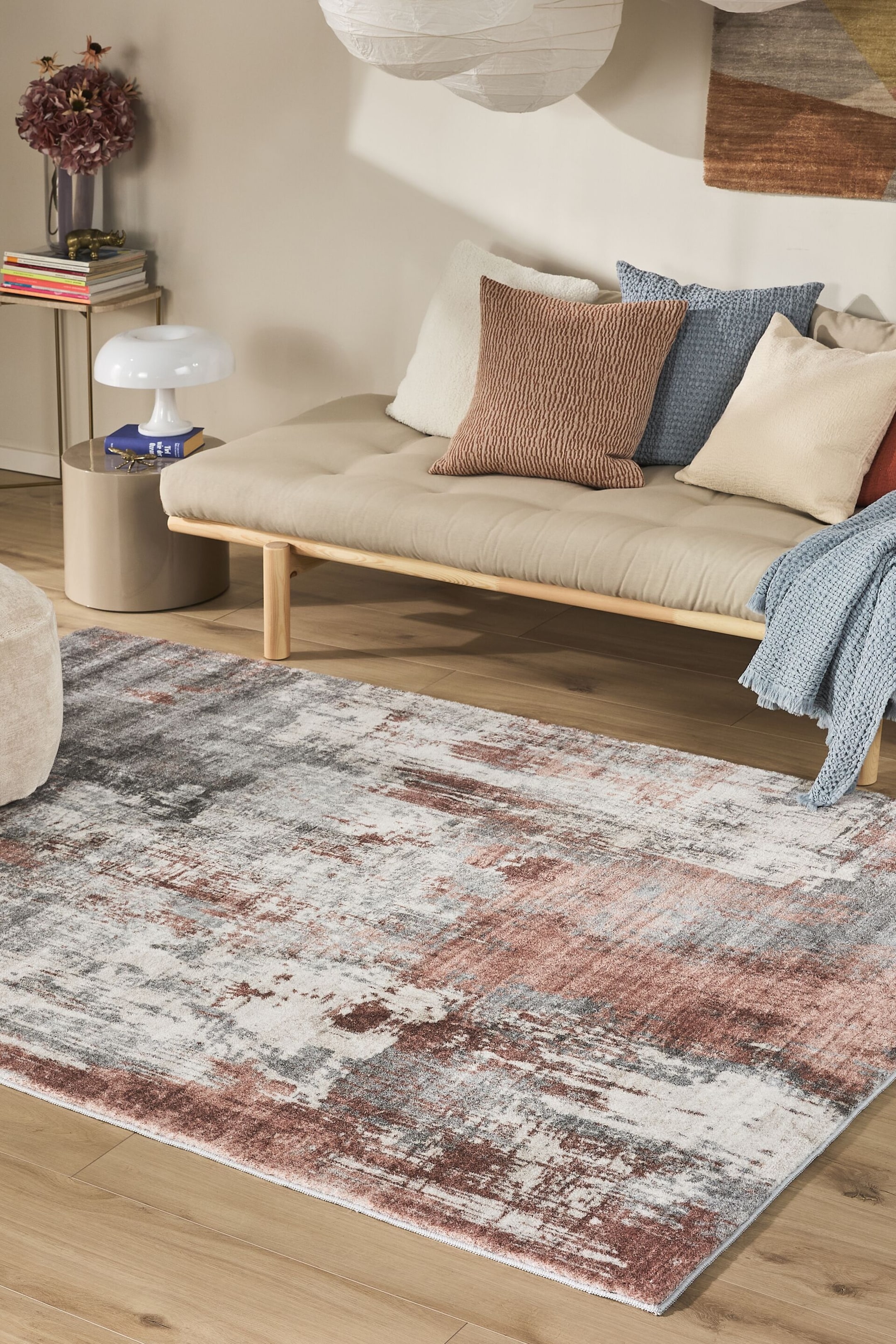 Visualizza immagine più grande: Un tappeto rettangolare è posato su un pavimento in legno, disposto diagonalmente dal basso a sinistra verso l'alto a destra. Presenta un motivo astratto e vissuto con colori bianco, grigio e marrone rossiccio.