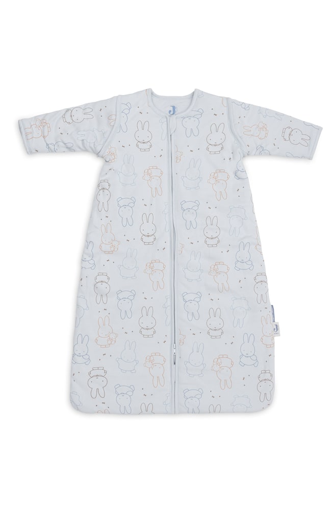 Un sac de couchage pour bébé bleu clair à manches longues, avec une fermeture éclair centrale sur le devant, est posé à plat et présente un motif intégral de personnages de lapin illustrés et de petites étoiles. - 1