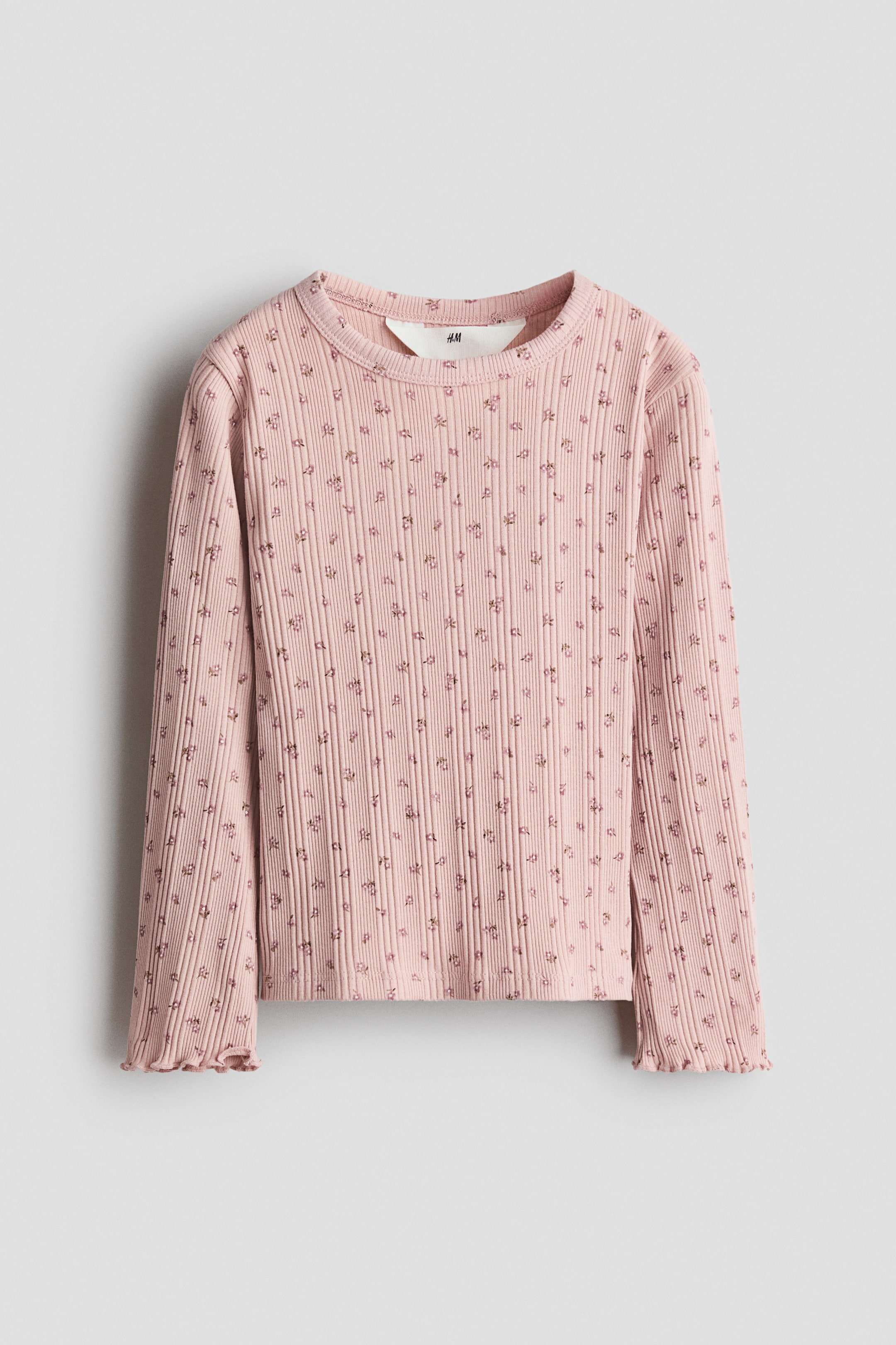 View larger image: A pink long-sleeved top in ribbed cotton jersey is laying flat, featuring an all-over small floral print. It has a round neckline with a narrow trim and overlocked edges at the cuffs.