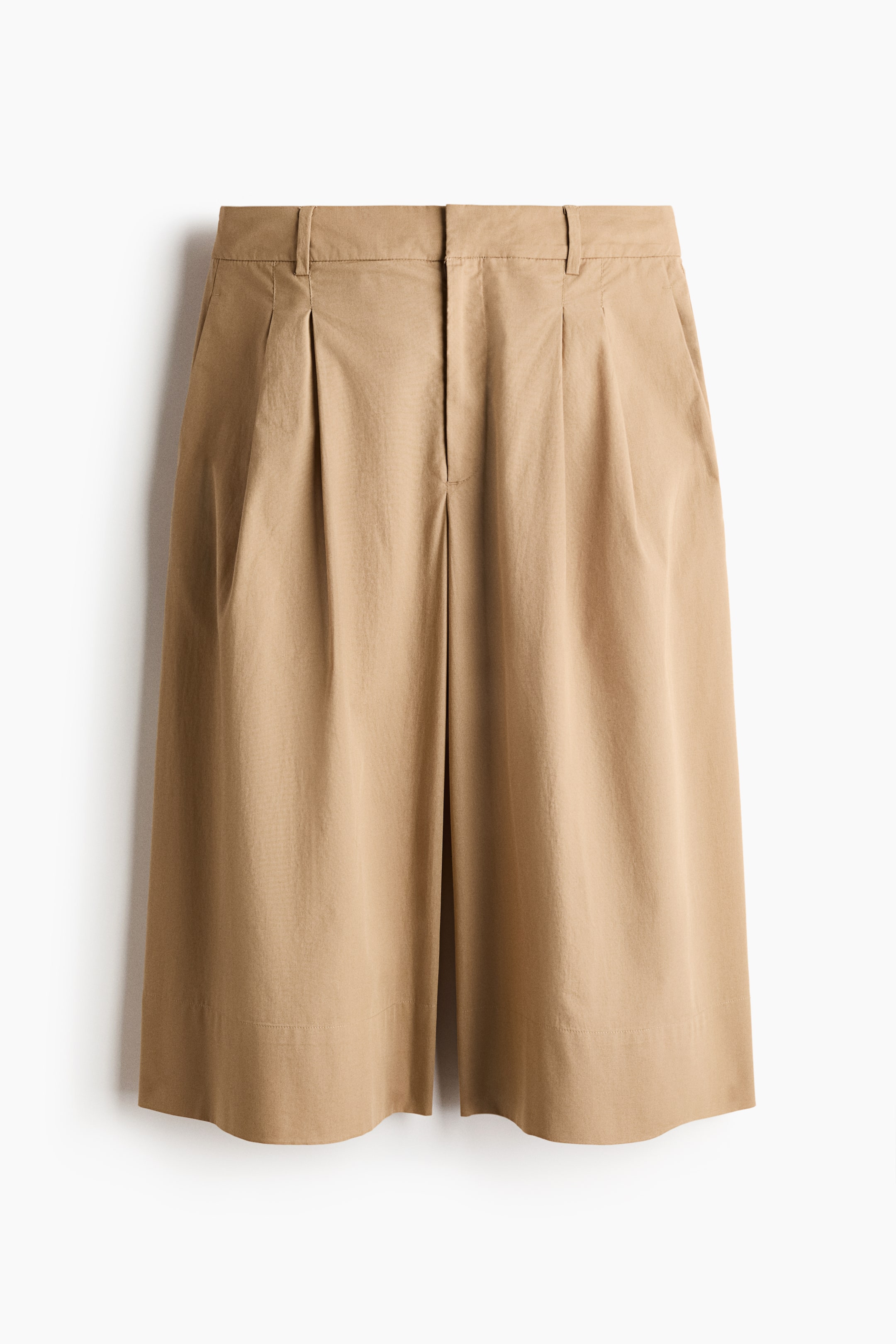 View larger image: Light brown shorts are displayed in a front view, showcasing a flat waistband with belt loops, a concealed zipper fly, and single pleats on each side. Side slash pockets are evident, and the shorts conclude with a neat hem above the knee.