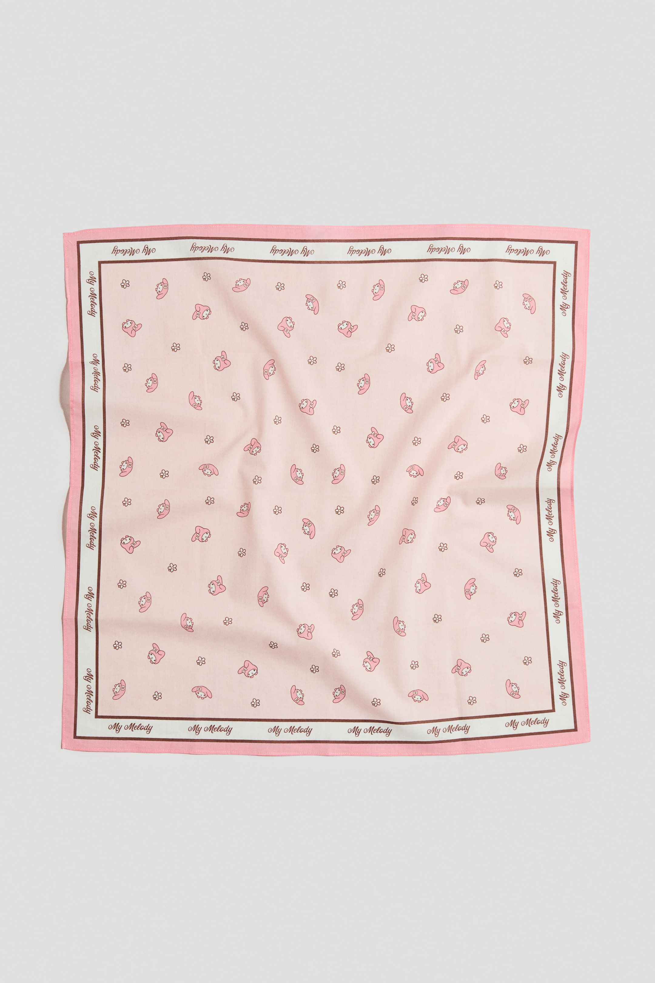 View larger image: A square, printed cotton scarf is laid flat from the front, showcasing a light pink base adorned with a scattered pattern of small pink My Melody characters and brown flowers. The scarf is framed by a multi-layered border, featuring a wider pink band, a thin white line, a thin dark brown line, and a white stripe repeating the 'My Melody' text in dark brown.