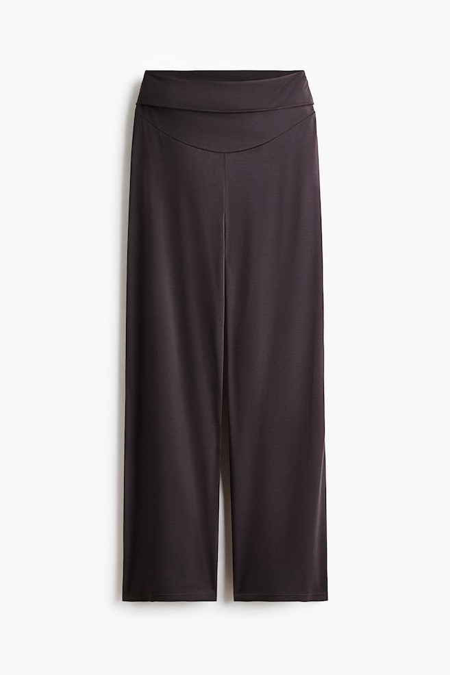 Dark brown yoga pants are shown from the front, featuring a high waist with a wide, foldover waistband and straight, wide legs in a smooth jersey fabric. - 1