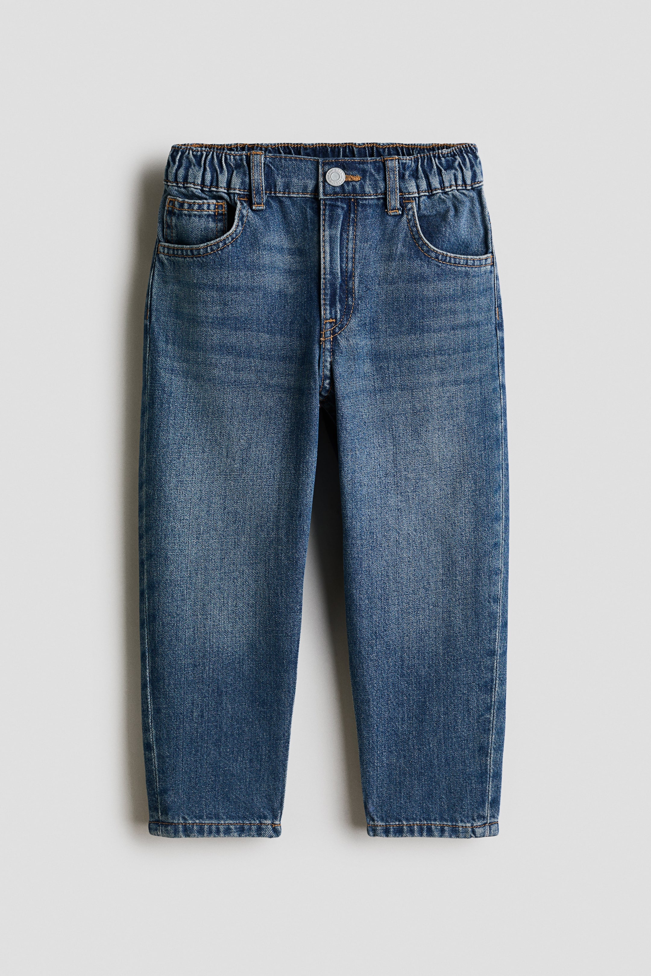 View larger image: These 5-pocket jeans offer a front view, crafted from washed cotton denim, showcasing a loose fit through the hip and thigh. They feature balloon legs that taper to the hems, an adjustable elasticated waist with belt loops, and a zip fly with a button closure.