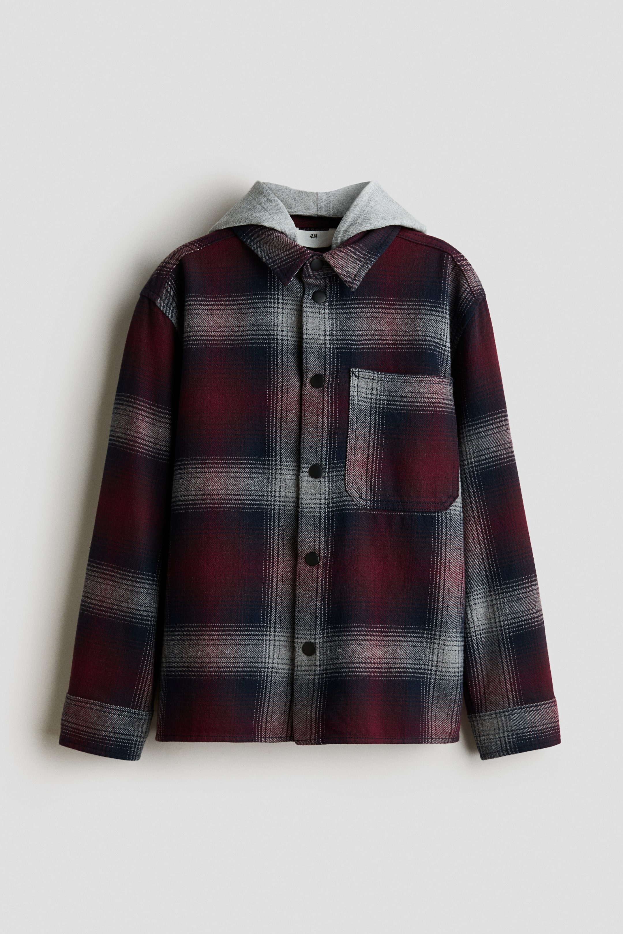 Näytä suurempi kuva: Hupullinen ruutupaita-tyylinen takki on ripustettuna eteenpäin suuntautuvassa kuvassa. Siinä on viininpunainen, laivastonsininen ja harmaa ruutukuvio sekä kiinnitetty vaaleanharmaa jersey-huppu. Mallissa on klassinen paitakaulus, edessä nepparikiinnitys, yksi rintatasku paikkataskuna sekä pitkät hihat nappikalvosimilla.