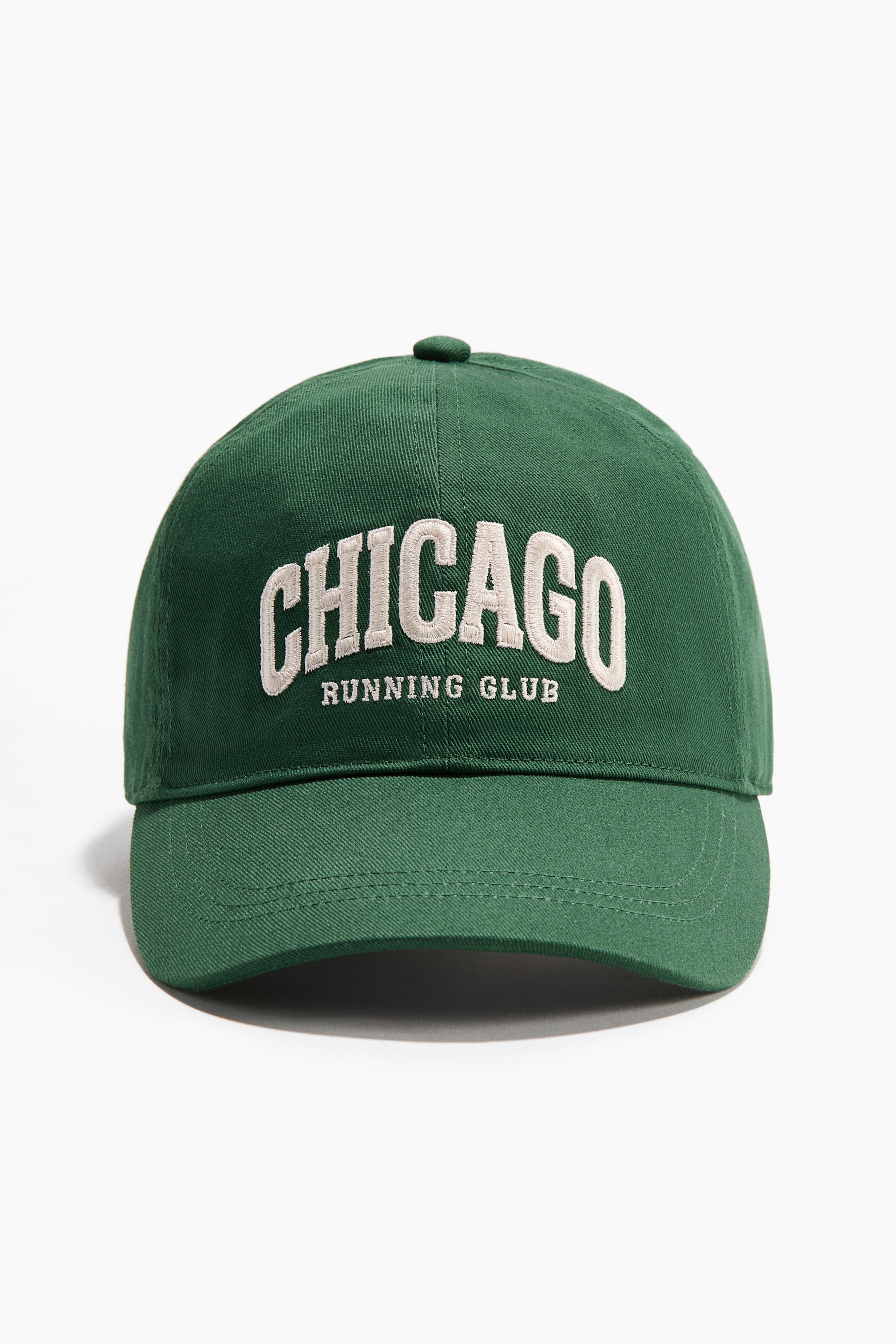 Ver imagen más grande: Se presenta una gorra de sarga de algodón de color verde oscuro como FRENTE, con "CHICAGO" bordado en grandes letras elevadas de color blanco roto con "RUNNING CLUB" debajo, y un botón redondeado en la parte superior.