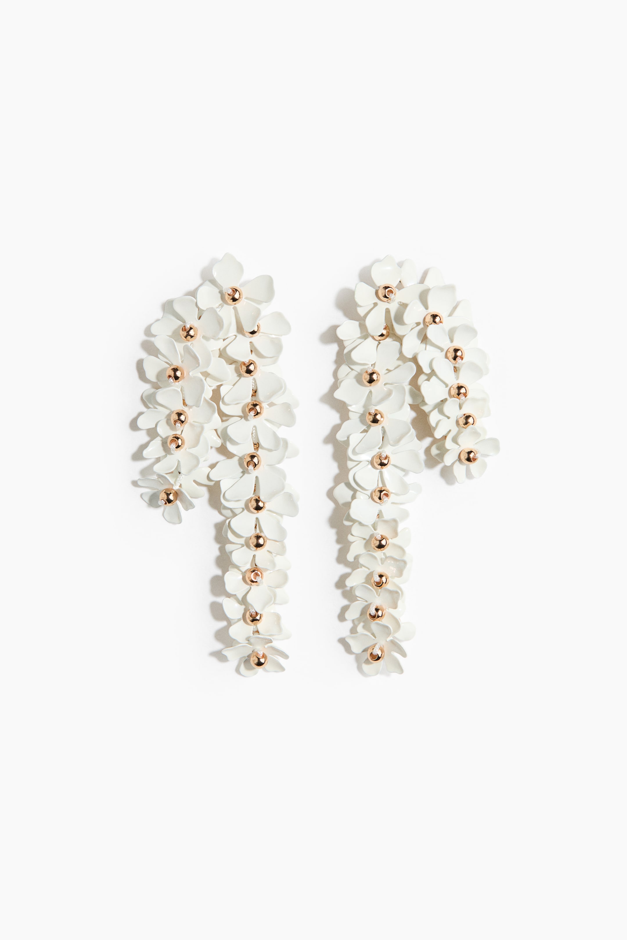 View larger image: A pair of white floral drop earrings is showcased FRONT. Each earring highlights several small white flowers, accentuated by a rose gold-toned bead at the center of each, creating a long, irregular cascade.