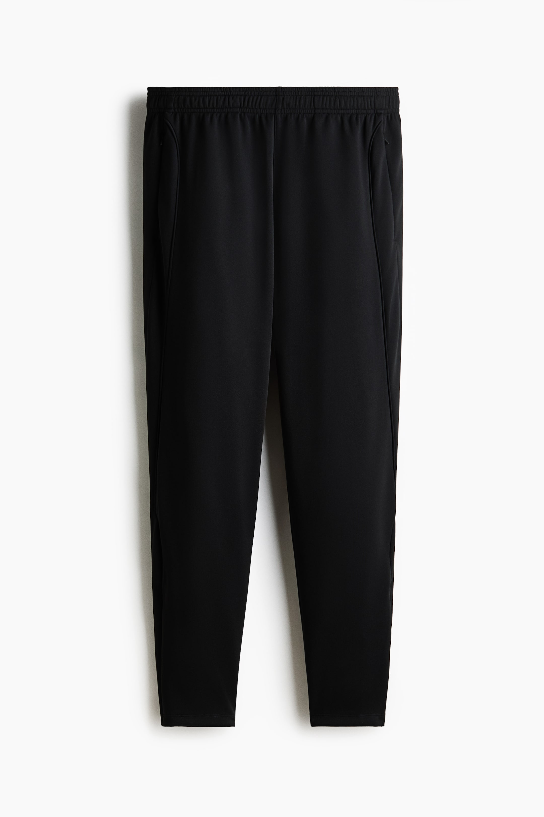 View larger image: Black pants shown from the front, with an elasticated waistband, inset side pockets and legs tapering to a plain hem.