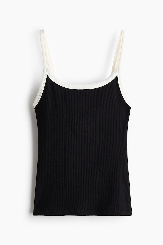 This fitted cami in black ribbed cotton jersey is shown from the front, featuring a contrasting white trim along the scoop neckline and narrow shoulder straps. - 1