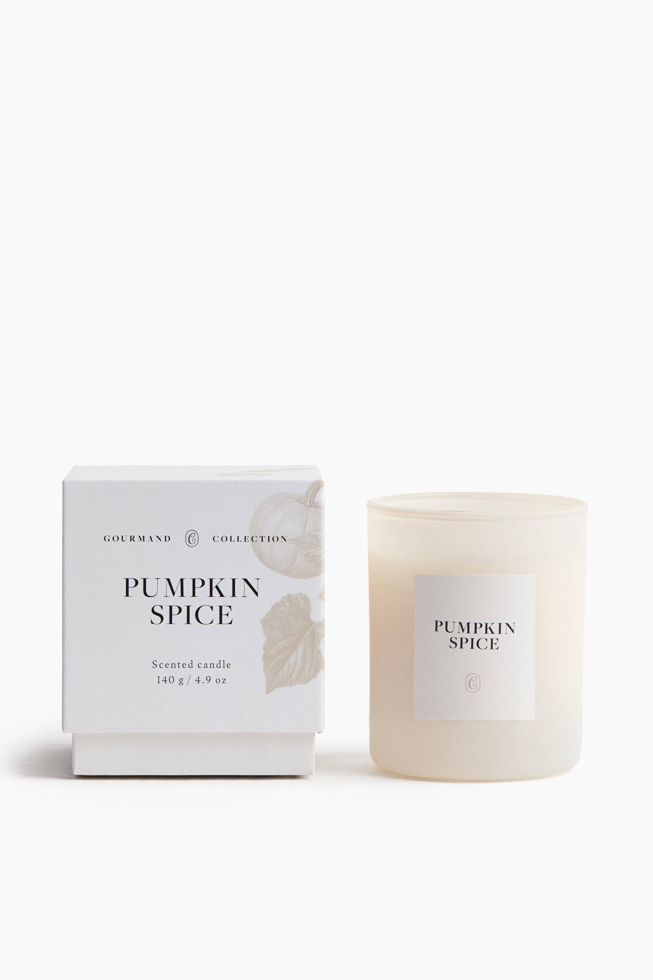 View larger image: A Pumpkin Spice scented candle in a frosted glass container is standing next to its white gift box, both facing front. The square box is showcasing elegant black lettering and a faint pumpkin illustration, coordinating with the minimalist white label on the cylindrical candle.