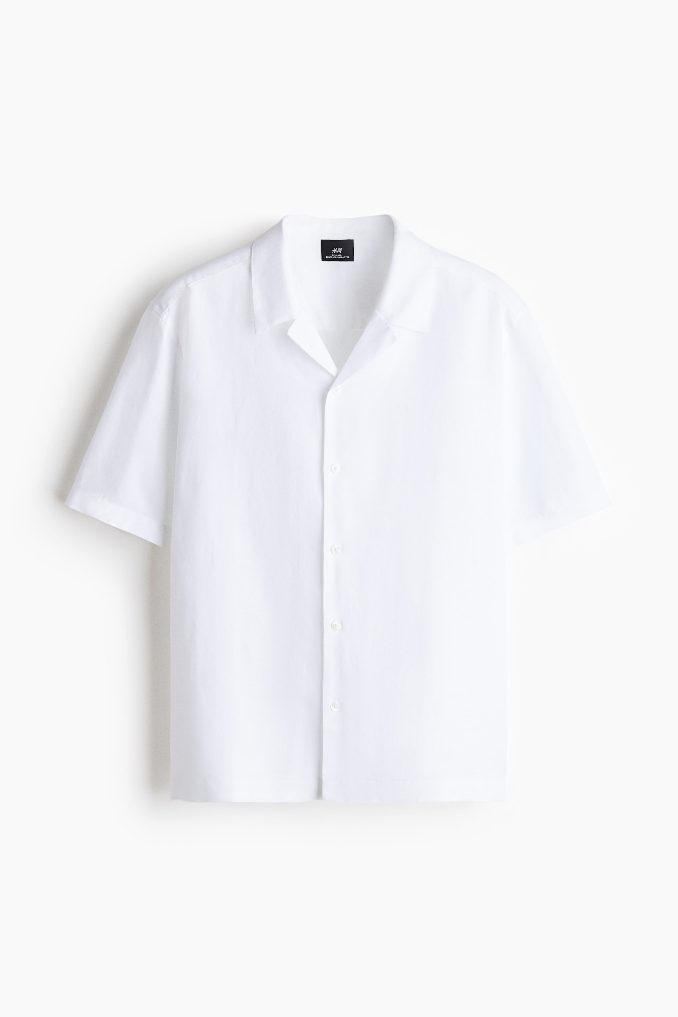 View larger image: A white short-sleeved shirt is displayed from the front, featuring a camp collar and a full button-front closure with round white buttons.