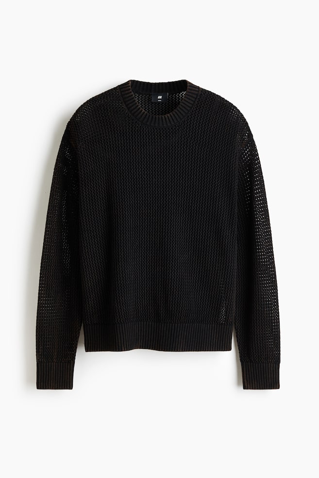 A black sweater is presented facing front, featuring a waffle-knit body and more open mesh-knit sleeves. It is designed with a crew neck and dark brown ribbed cuffs and hem. - 1