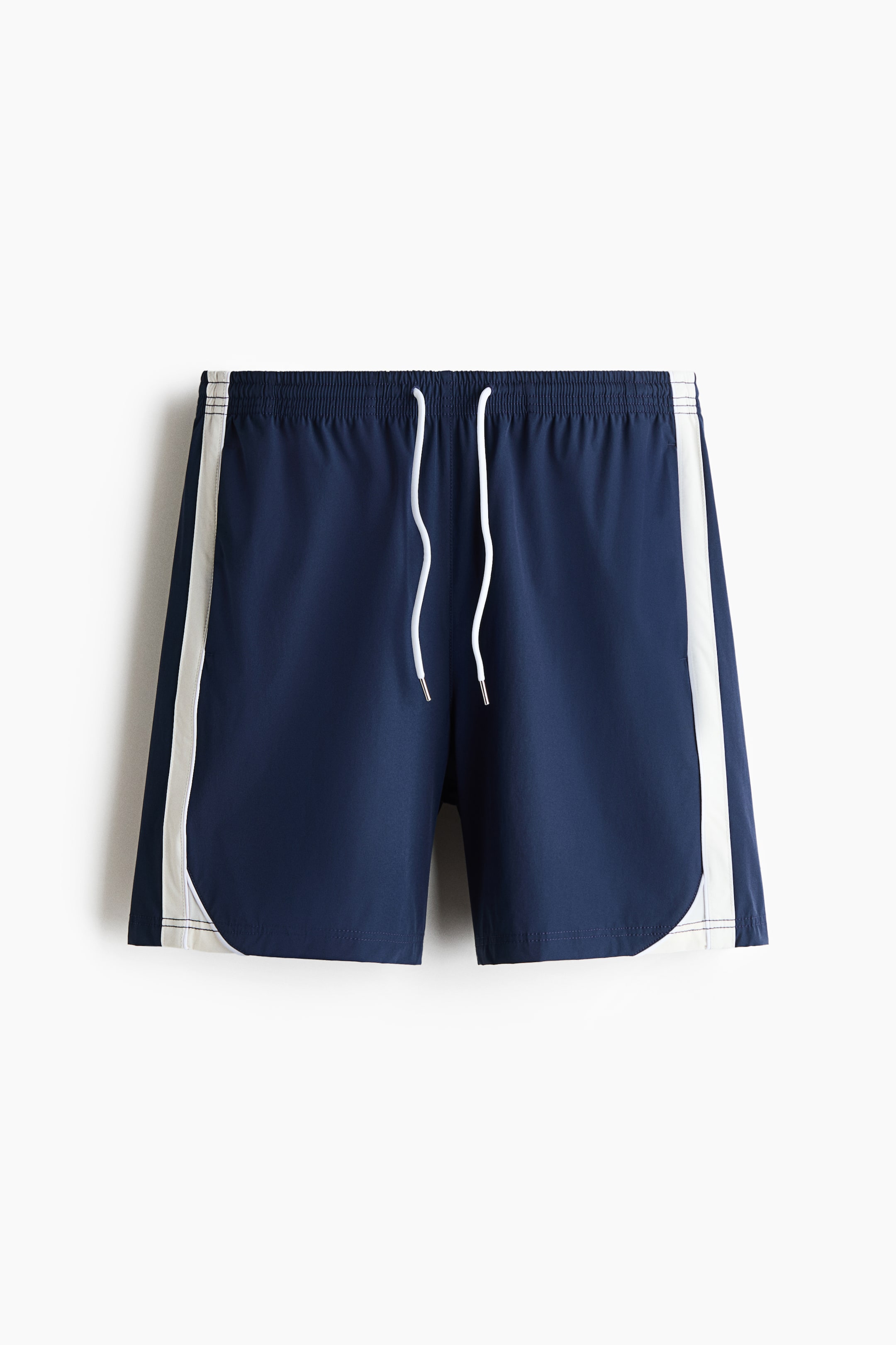 Voir une image plus grande: Les shorts de course bleu marine sont présentés de face, avec un cordon de serrage blanc à la taille et une élastication couverte. Des bandes blanches descendent de chaque côté, se courbant vers l'intérieur à l'ourlet inférieur.