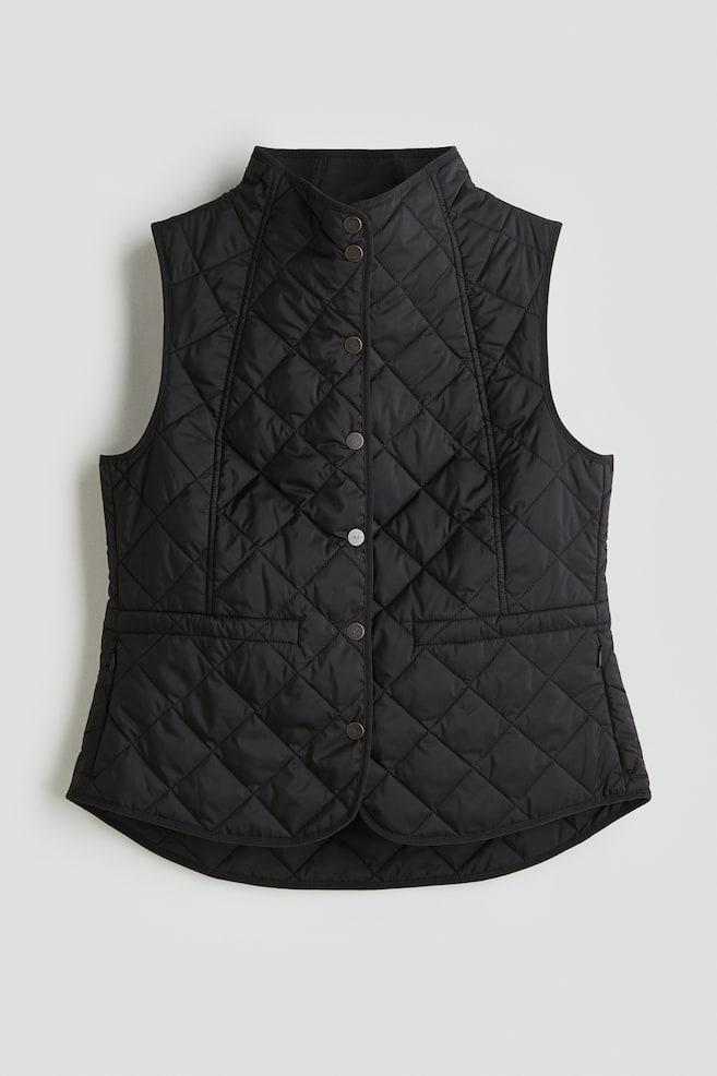 A black quilted vest is presented from the front, featuring a stand collar and a button-front closure with five dark buttons. It is designed with two flap pockets on the lower front and an all-over diamond quilting pattern. - 1