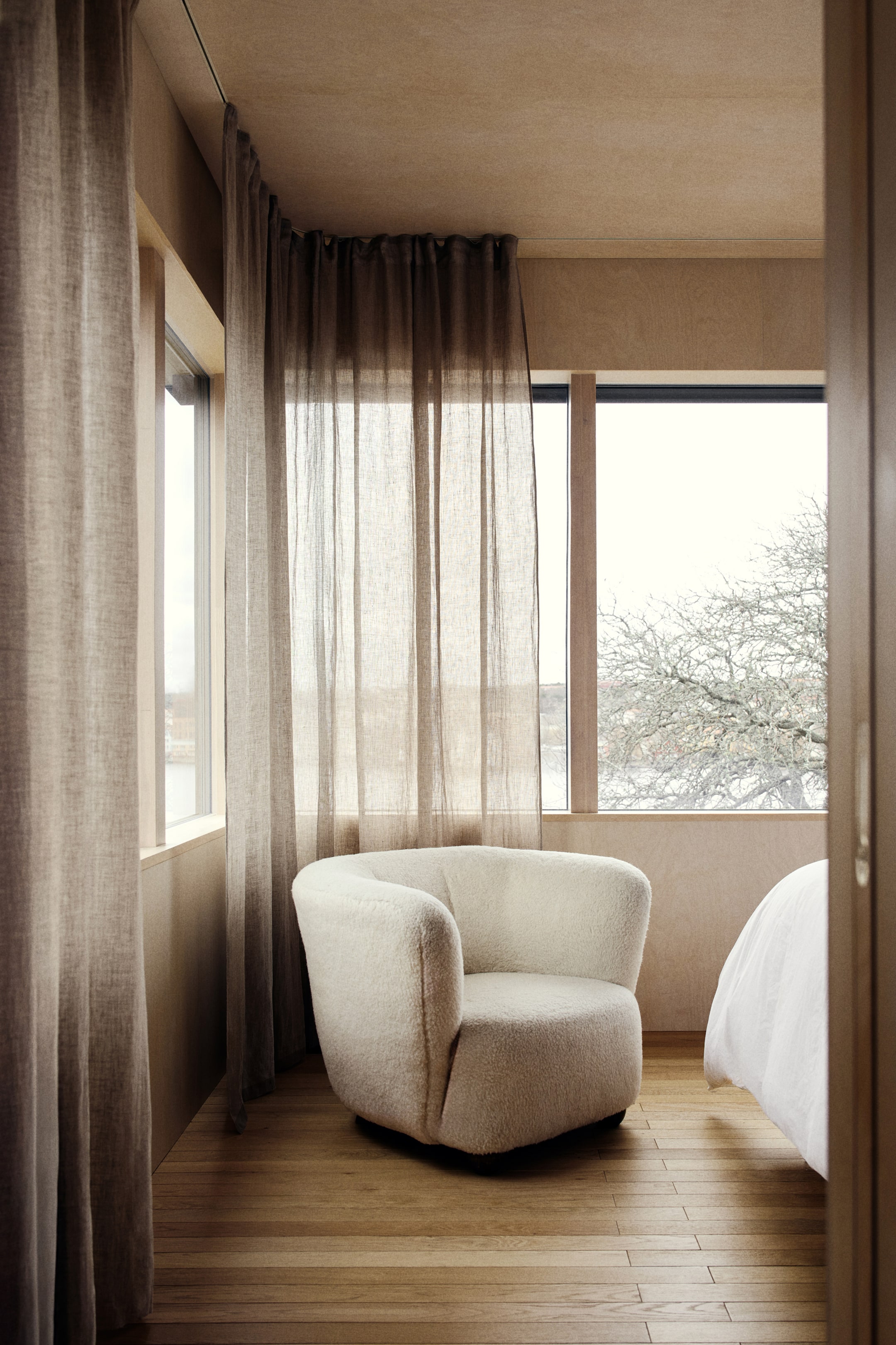 View larger image: An extra-long, wide curtain crafted from a semi-sheer linen weave is draped across a window, showcasing gentle vertical folds. Its multiway header creates a gathered effect along the top, allowing light to softly filter into the room.