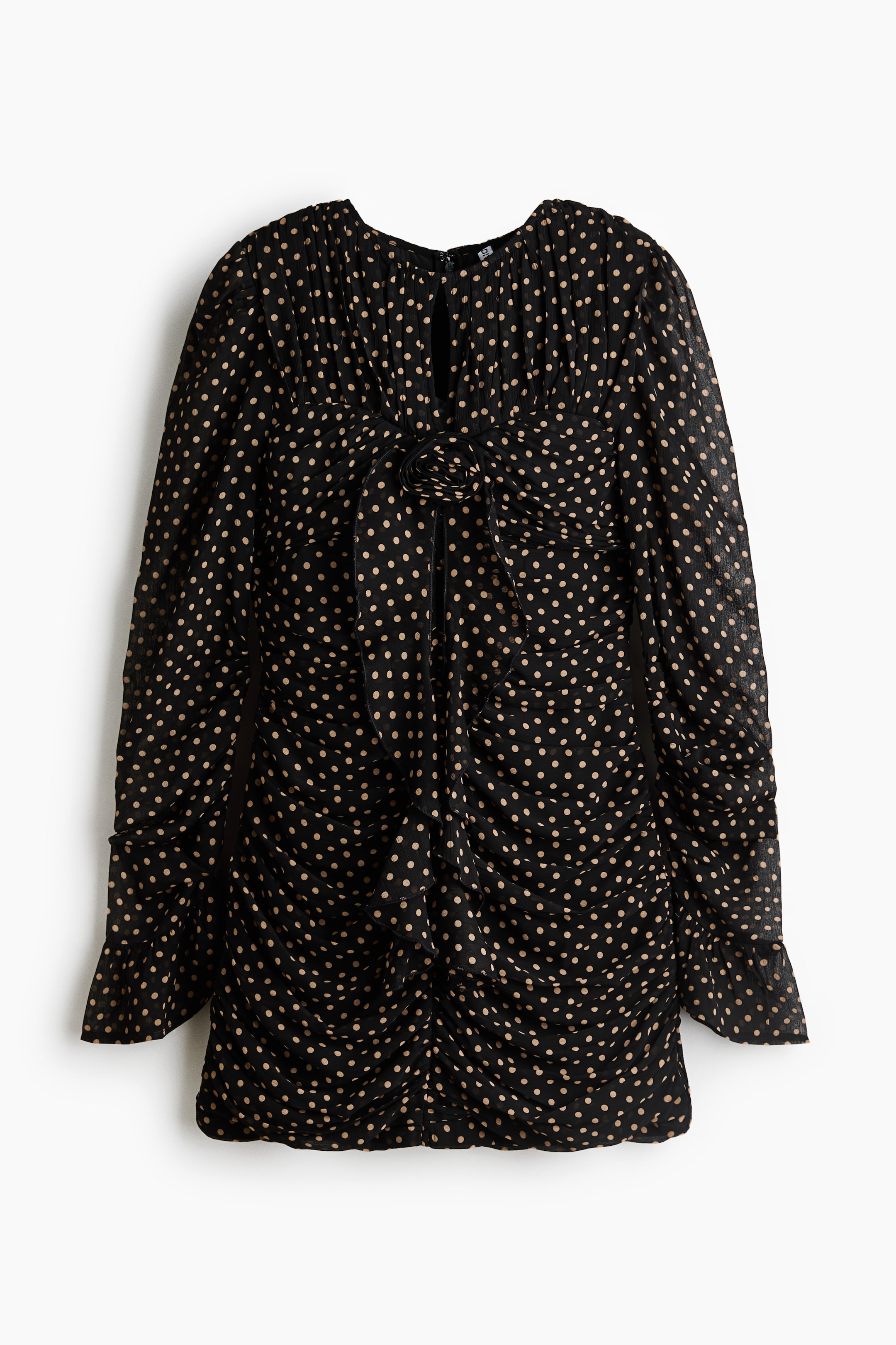 View larger image: A black long-sleeved mini dress with a beige polka dot pattern is shown from the front. The dress features all-over ruching, a small keyhole cutout at the gathered high neckline, and a fabric rosette detail at the centre bust with cascading ruffled fabric.
